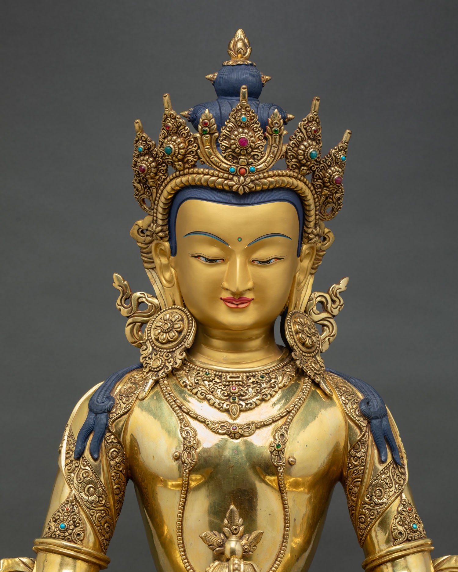 close up view of amitayus statue showing kalasha vase, gold gilded ornaments and fine detailing