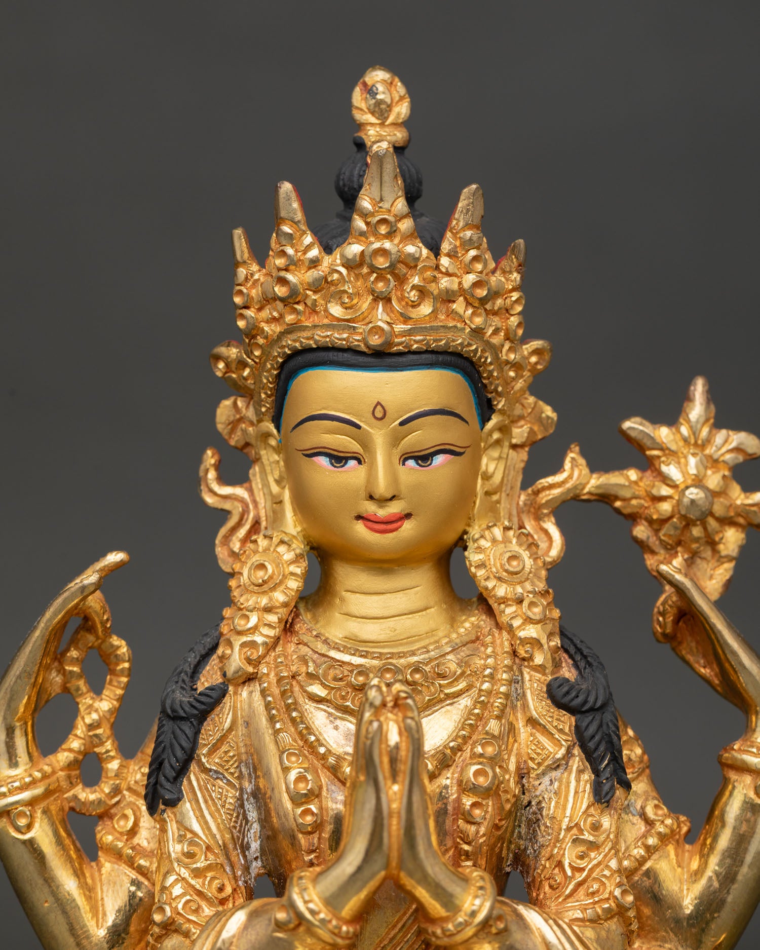 Close-up view of Chenrezig face showing serene expression, fine carving details, and traditional Himalayan Buddhist metal craftsmanship.