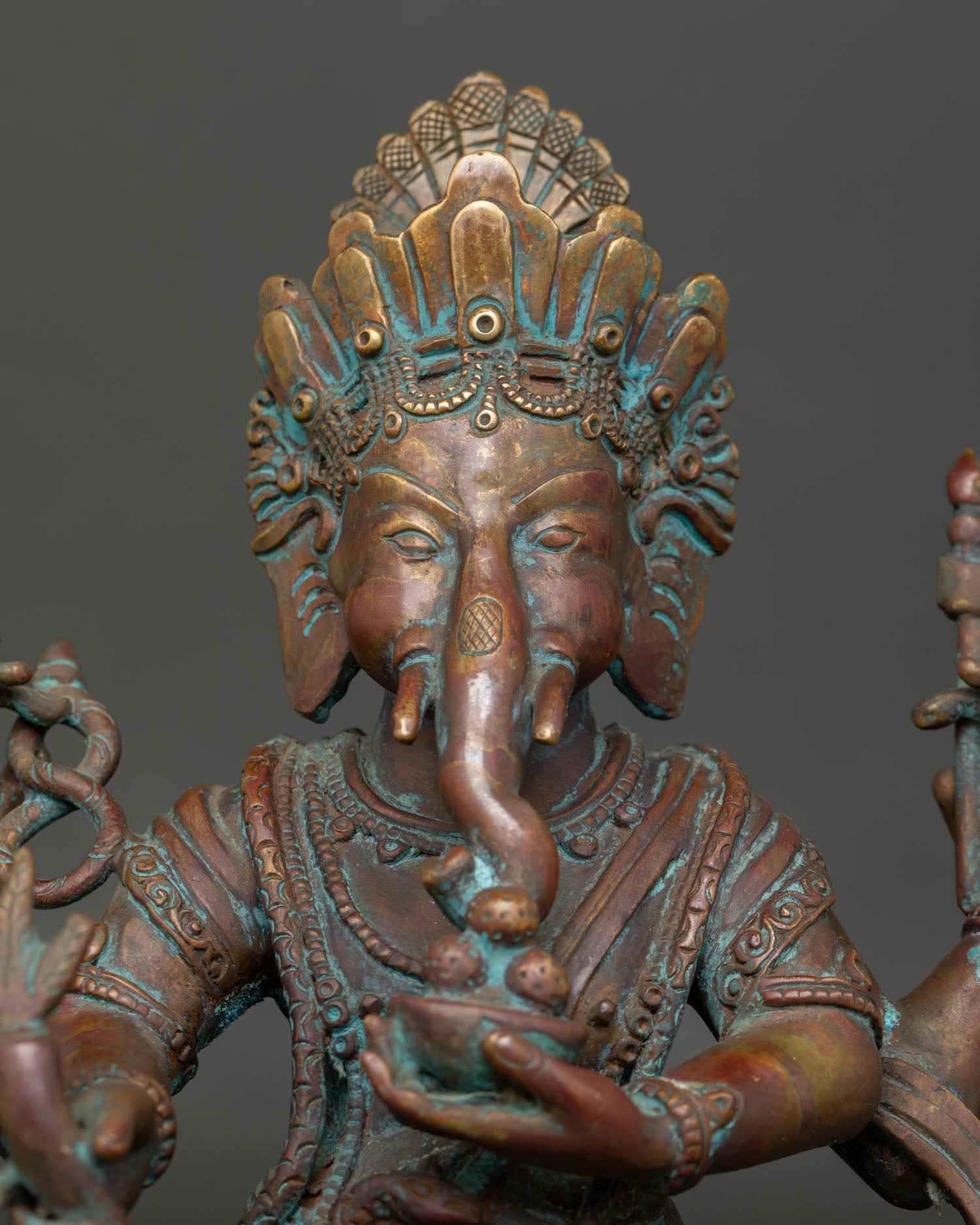 Close up view of Ganesh statue with sacred implements and intricate Newari details