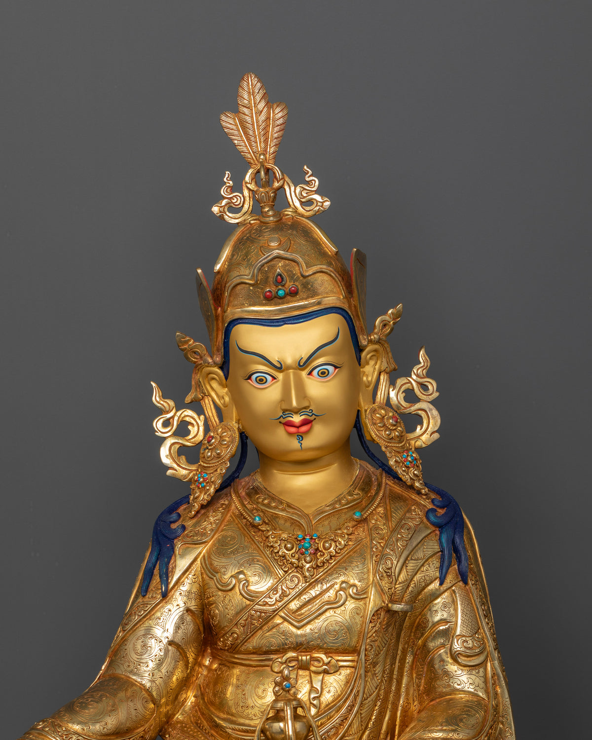 Close-up view of Guru Rinpoche Statue featuring a finely gold-painted face, 24K gold gilding, and intricate semi-precious stone details.