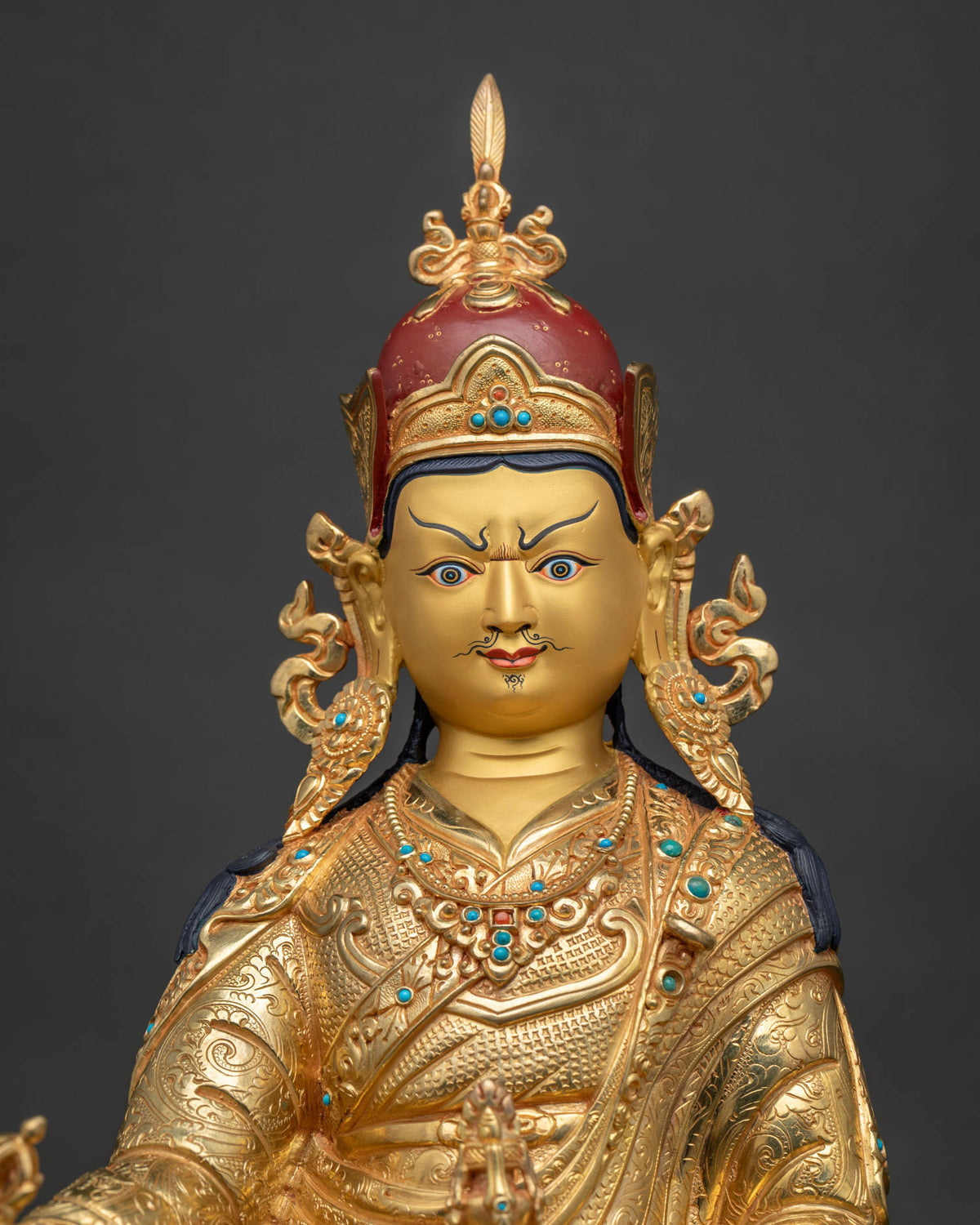 Close up view of handcrafted gold gilded Guru Rinpoche statue