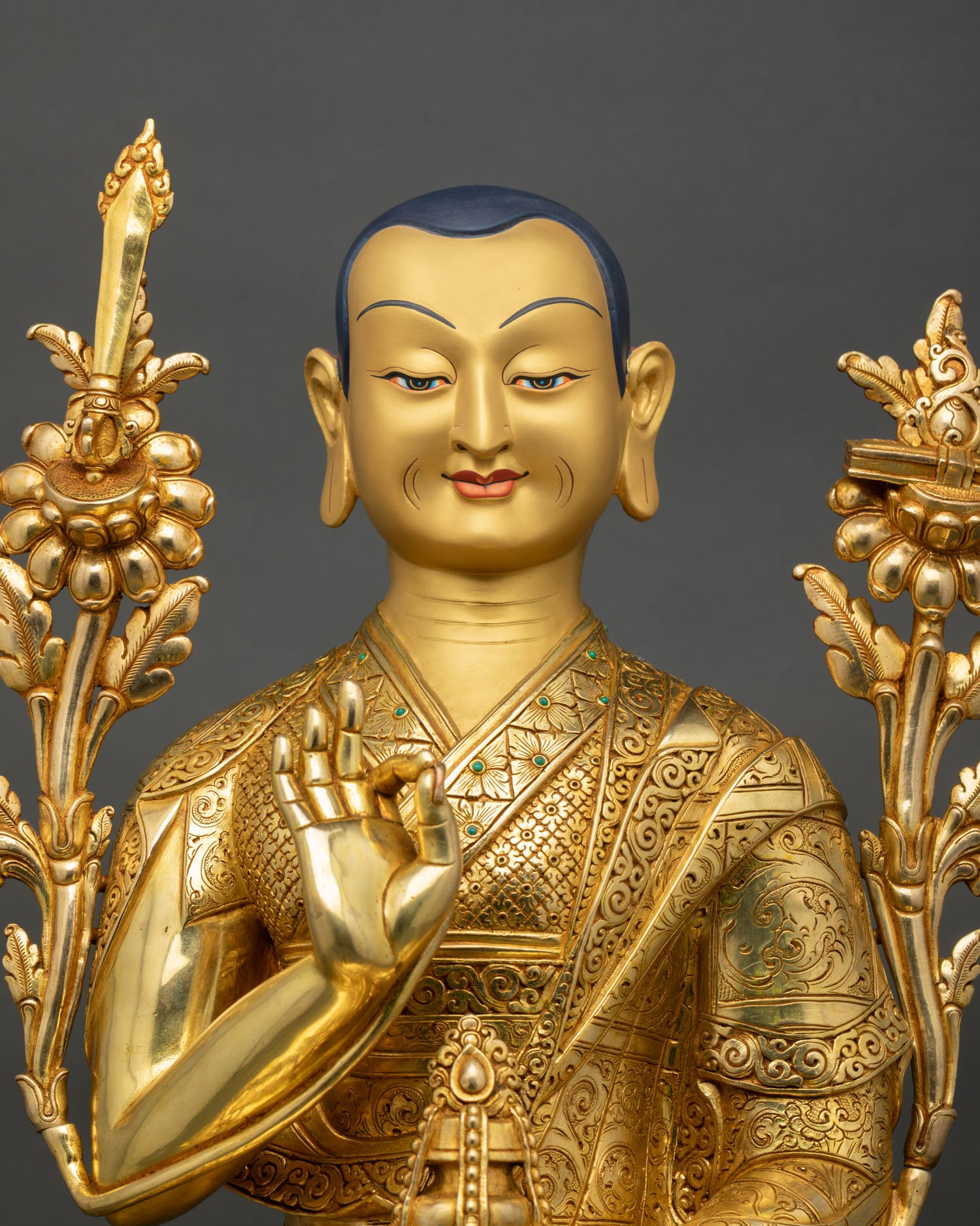 Close up view of Je Tsongkhapa sculpture showing gold painted face utpala stem Abhaya Mudra hand gesture and intricate Himalayan craftsmanship details