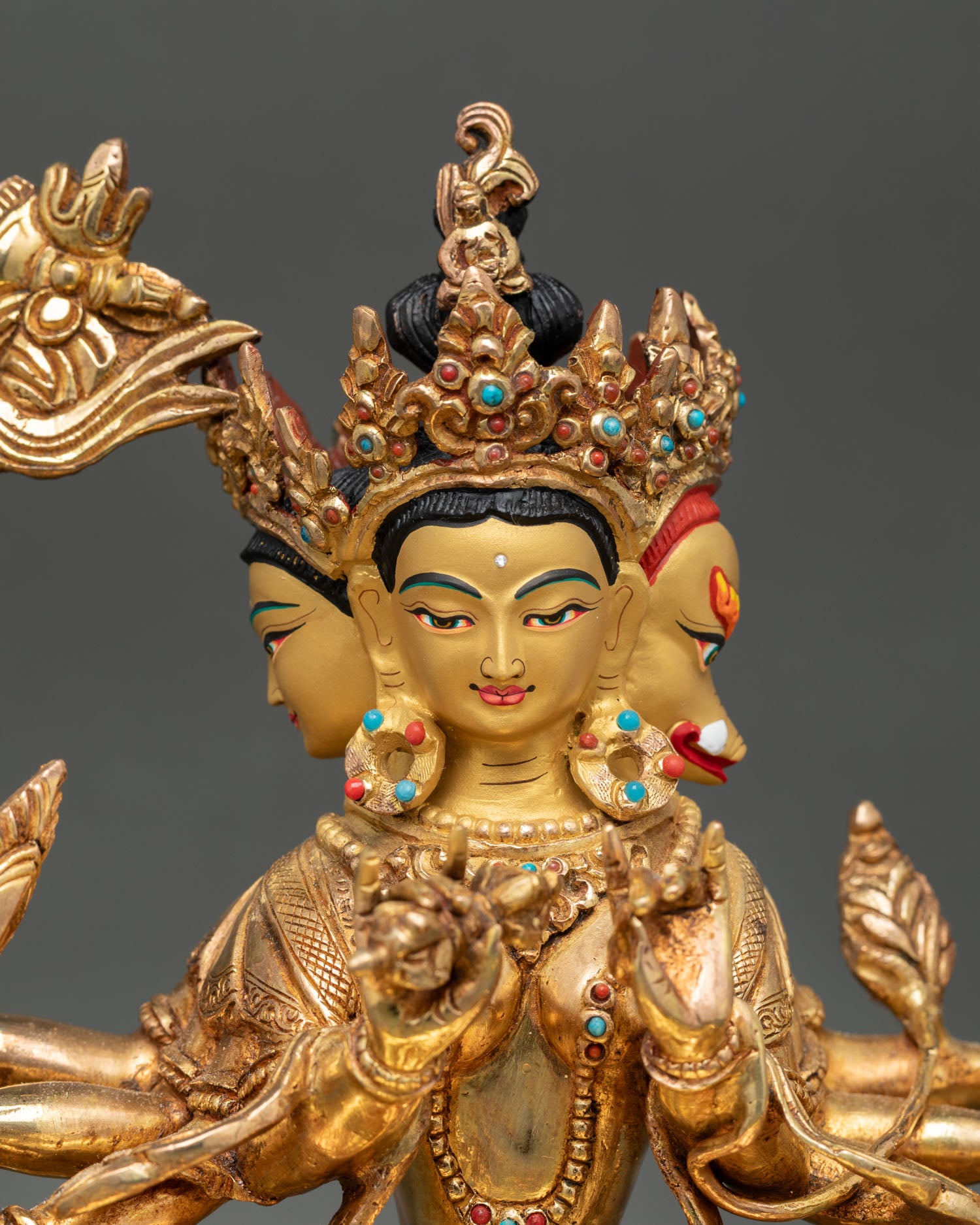 Close up view of Marichi deity statue gold painted face detailed facial expression sacred attributes in hands