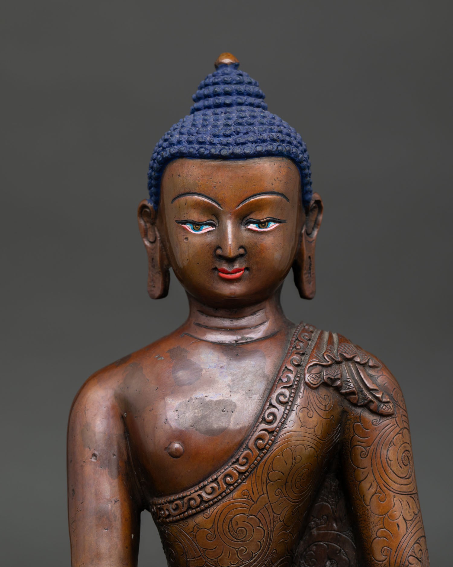 Close up view of Shakyamuni Buddha face and hand carved monk robe details handcrafted by Newari artisans.