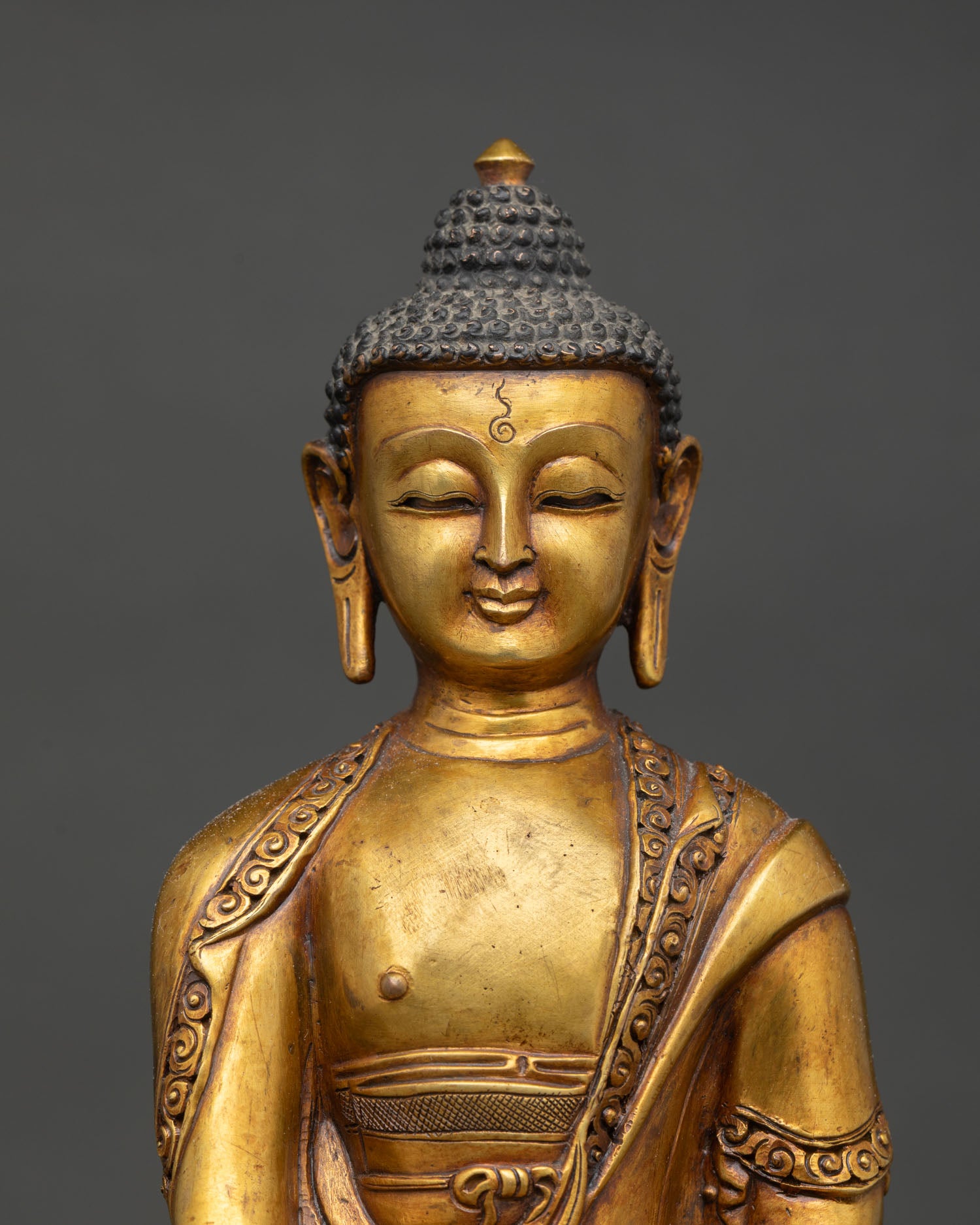 Close up view of Shakyamuni Buddha serene face with detailed antique finish texture and traditional Himalayan lost wax copper craftsmanship spiritual Buddha sculpture
