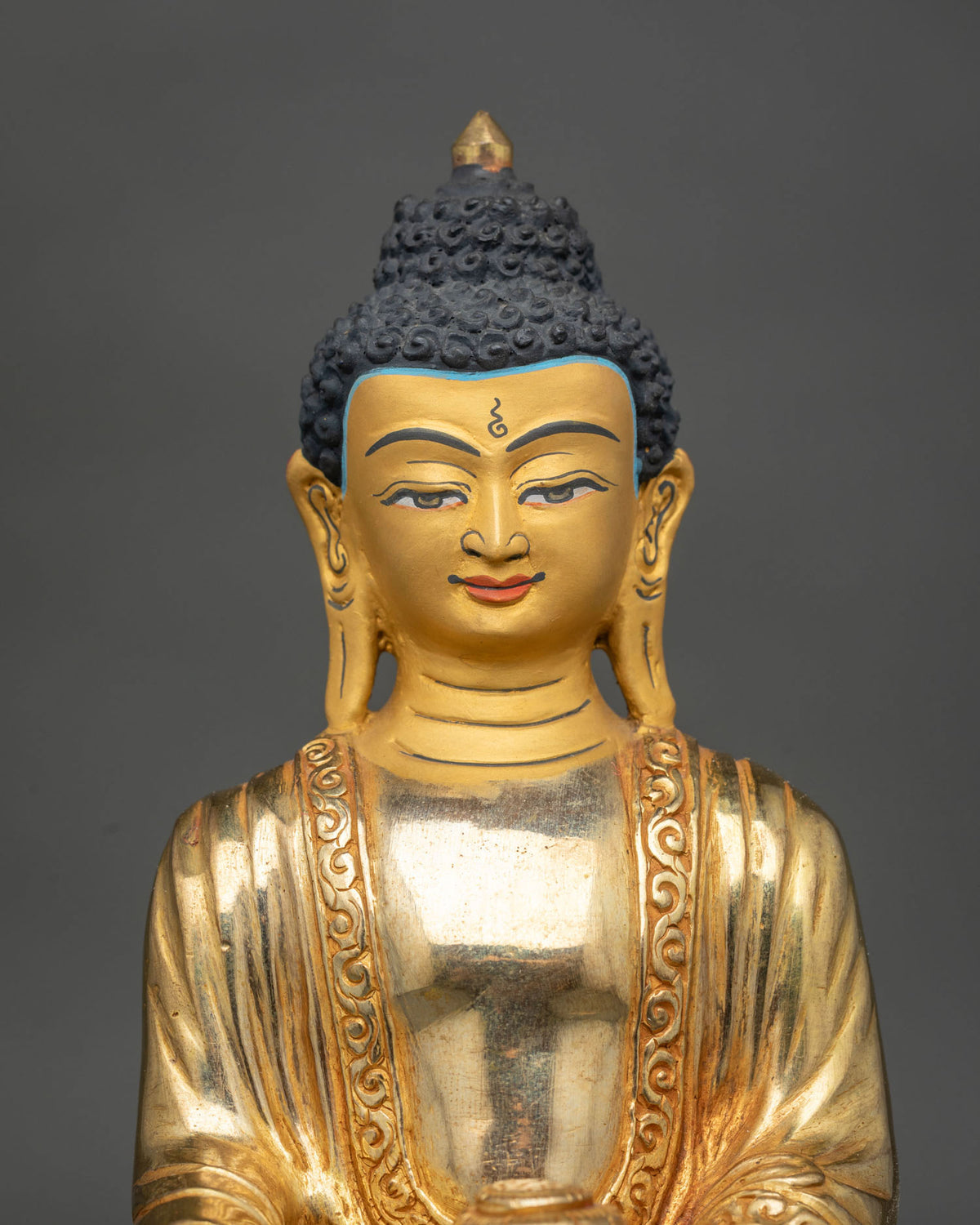 Close Up View of Shakyamuni Buddha Statue Gold Painted Face and Downcast Eyes