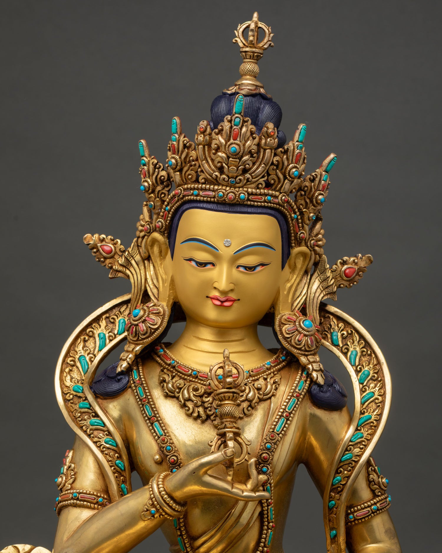Close up view of Vajrasattva Buddha statue showing gold painted face intricate details and Himalayan craftsmanship