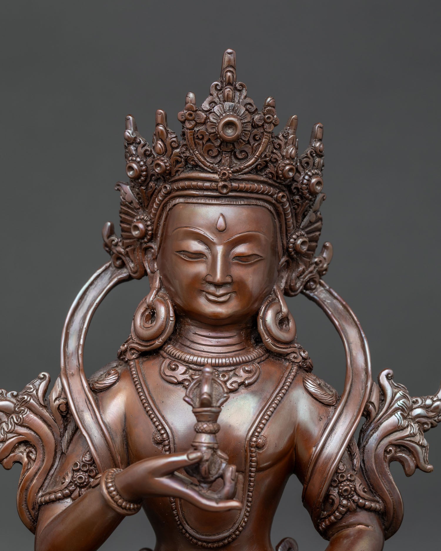 Close up view of Vajrasattva statue with serene expression and five pointed crown