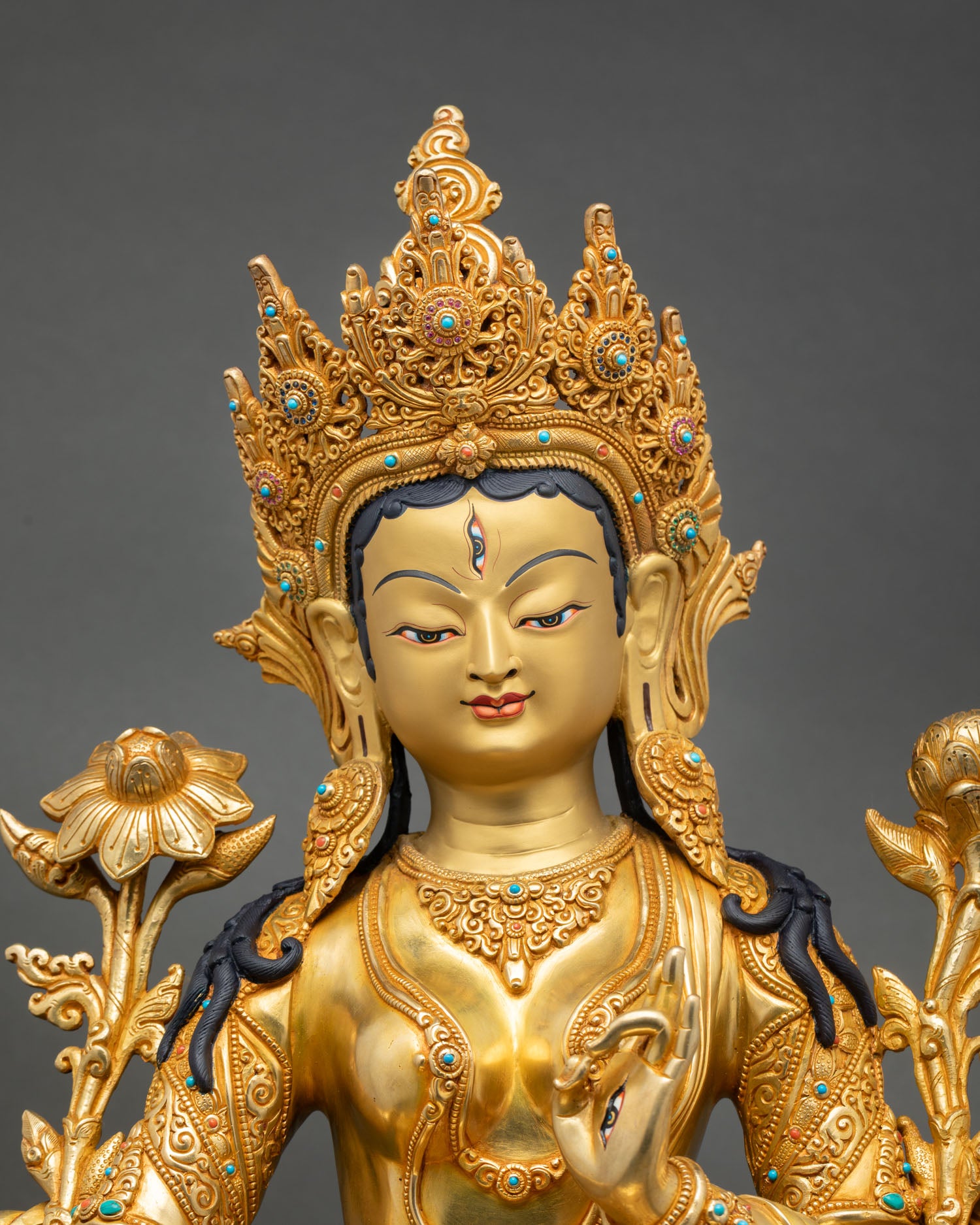 Close up view of White Tara goddess statue showing gold toned serene face Himalayan craftsmanship