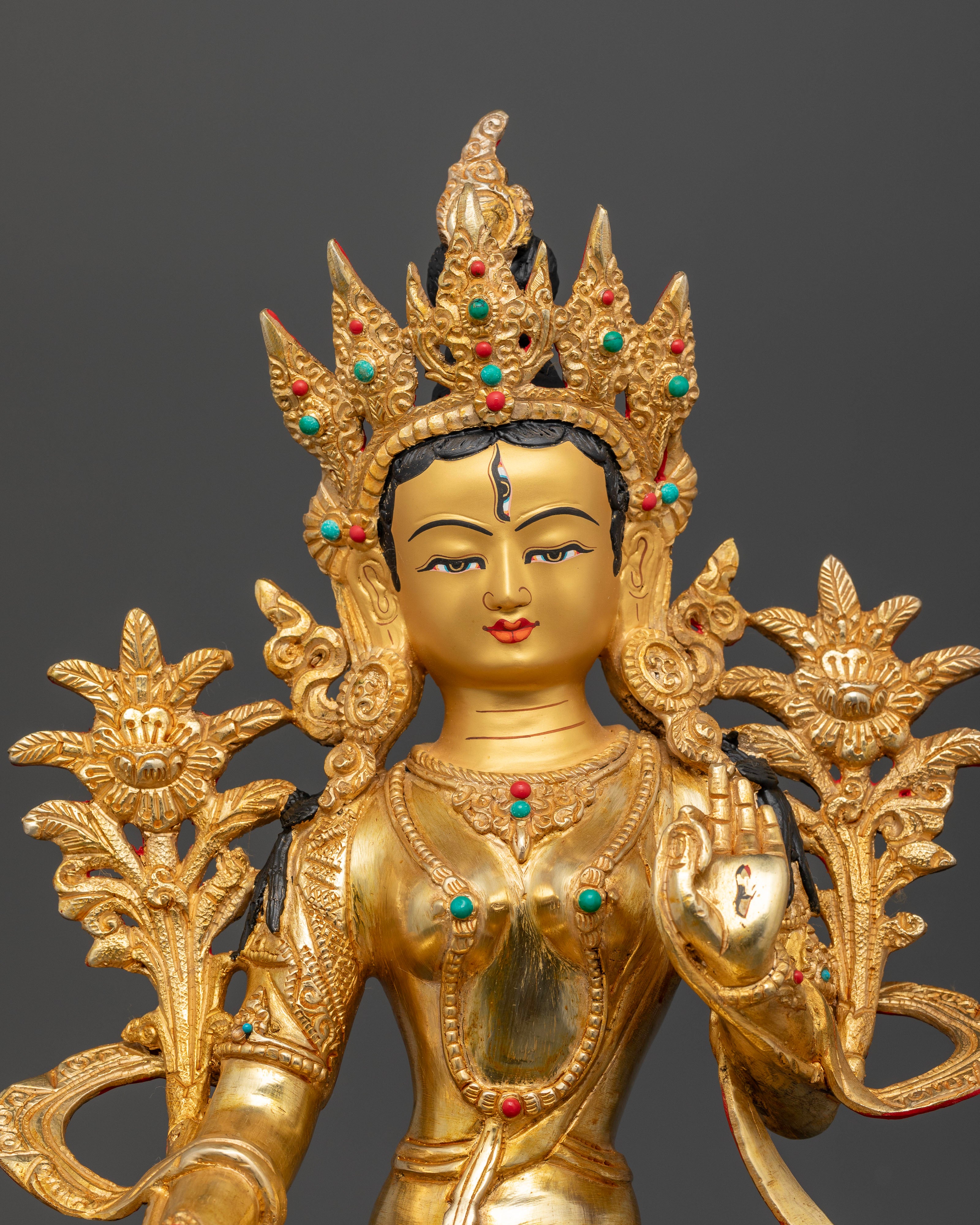 Close up view of White Tara with gold painted face and semi precious stone inlays