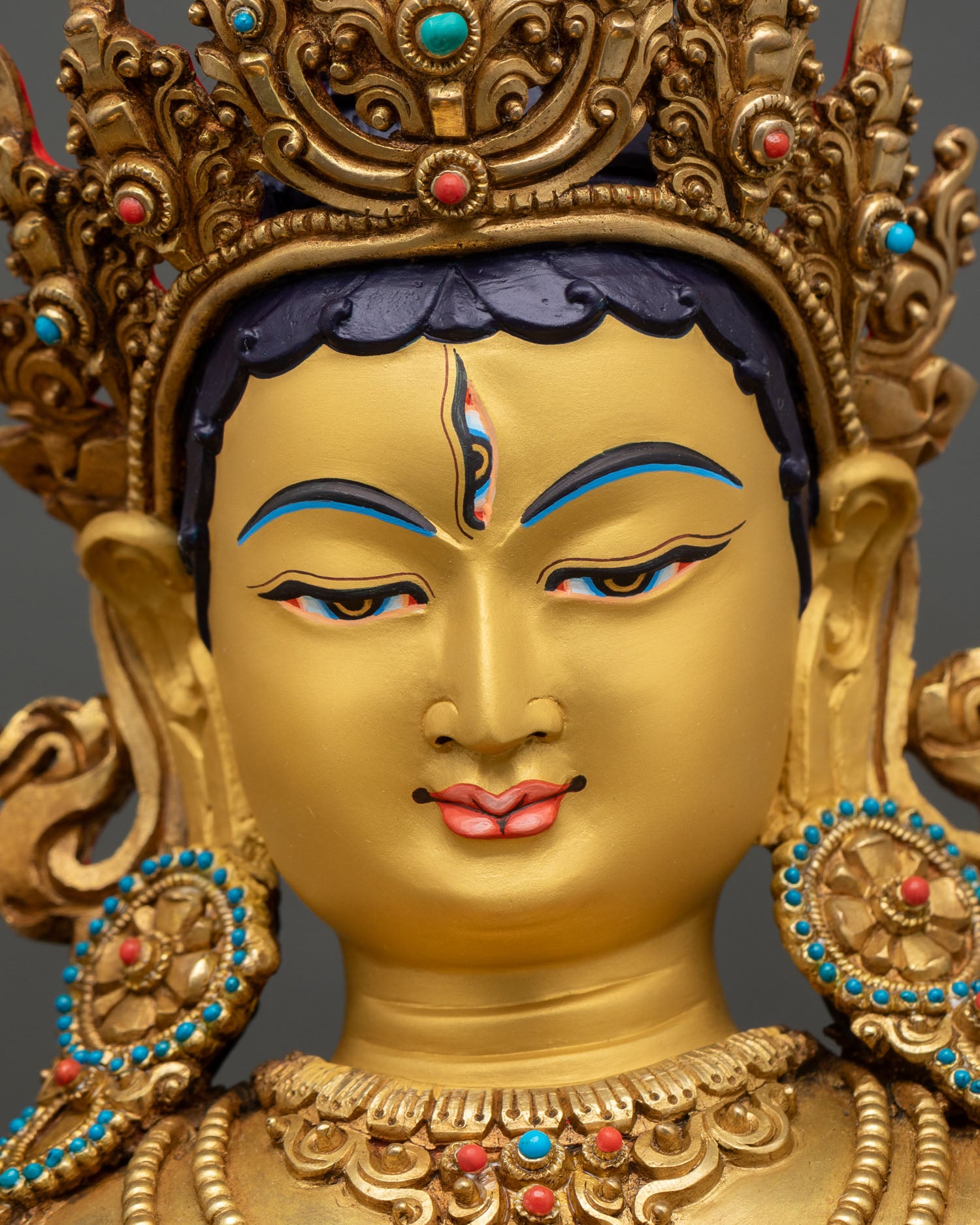 Close up view White Tara Buddhist statue showing gold painted features and fine Newari craftsmanship.