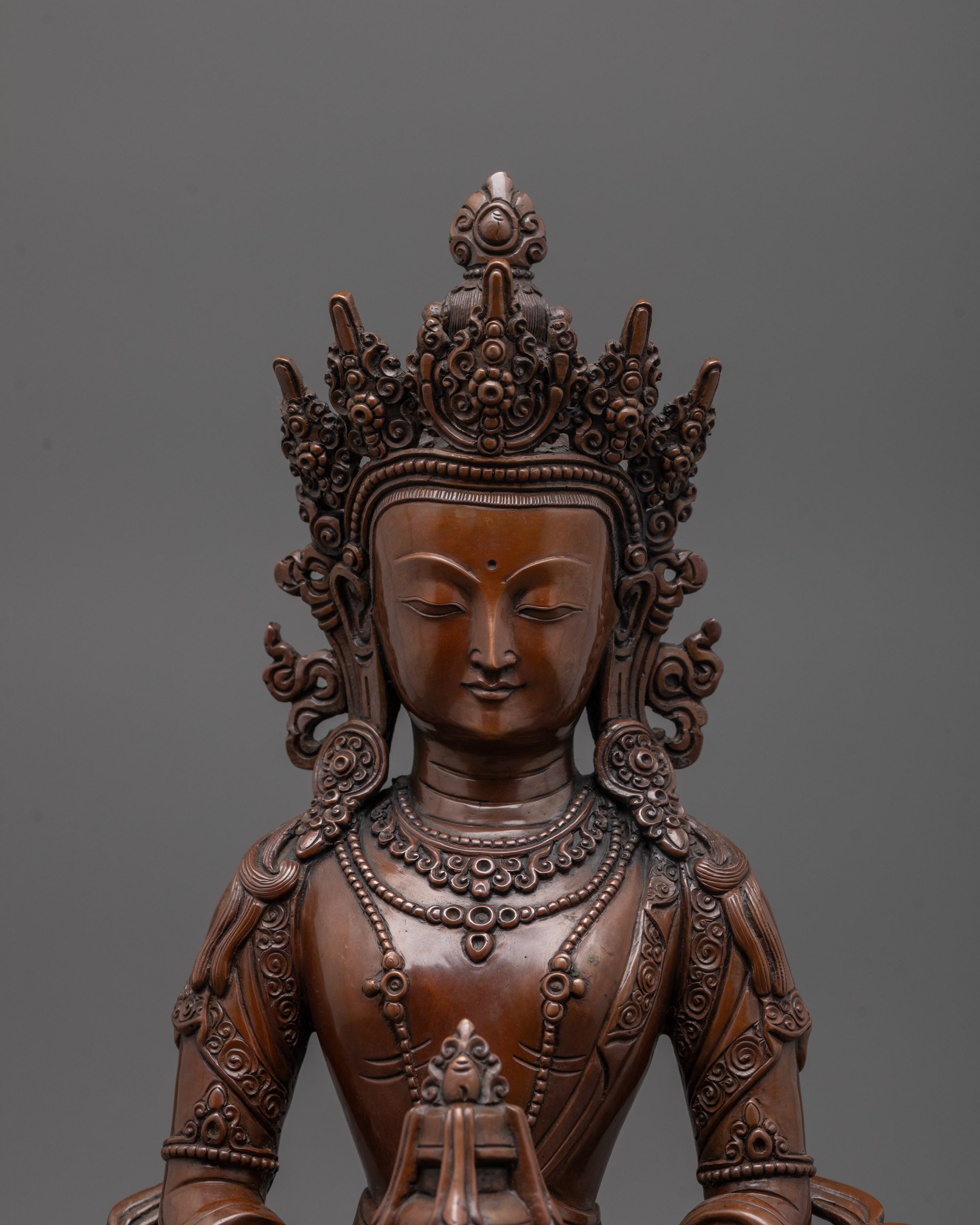 close-up of Amitayus crown and jewelry hand-carved by Nepalese artisans in oxidized copper