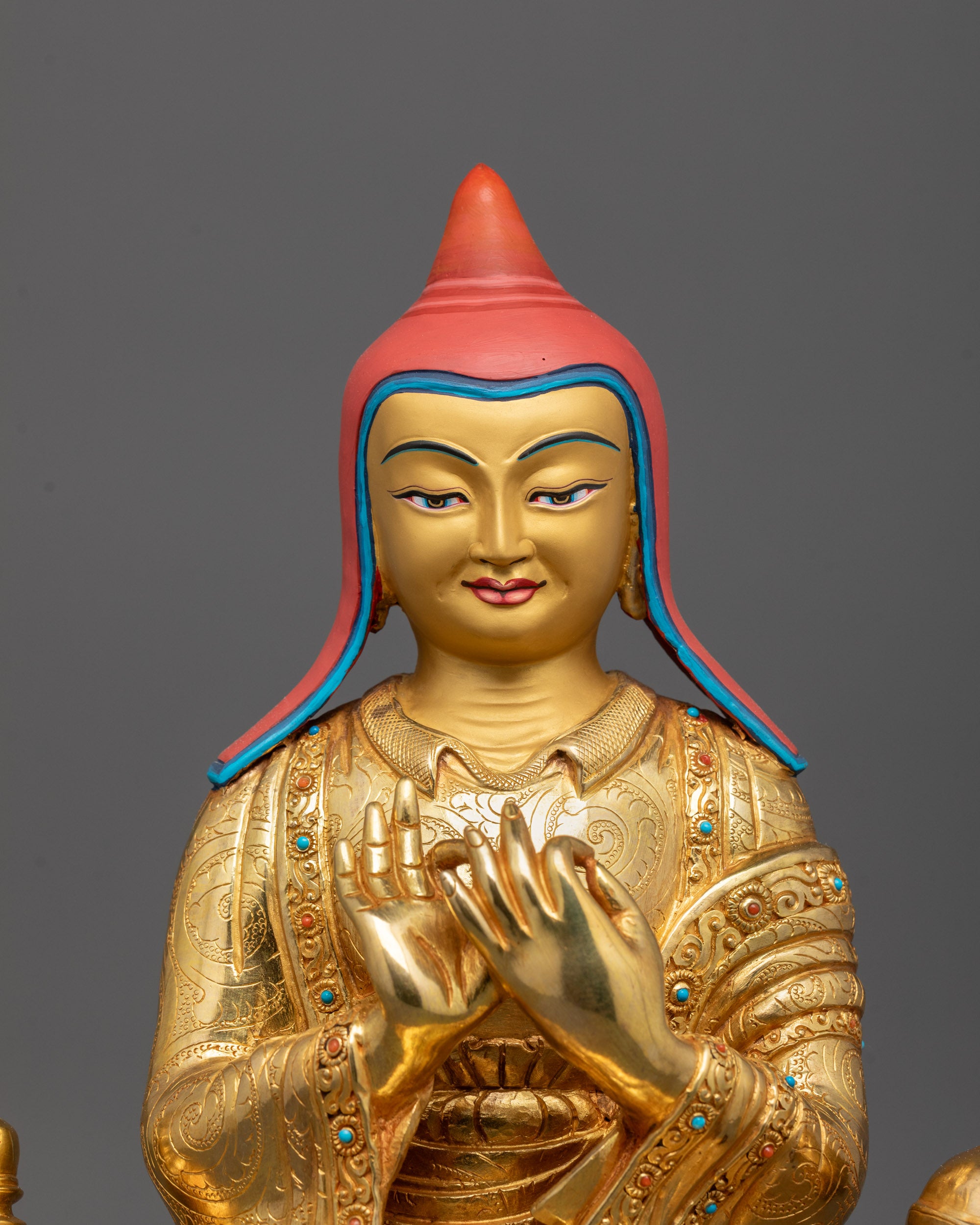 close-up of Atisa statue showing intricate carvings and calm expression on gold-gilded face