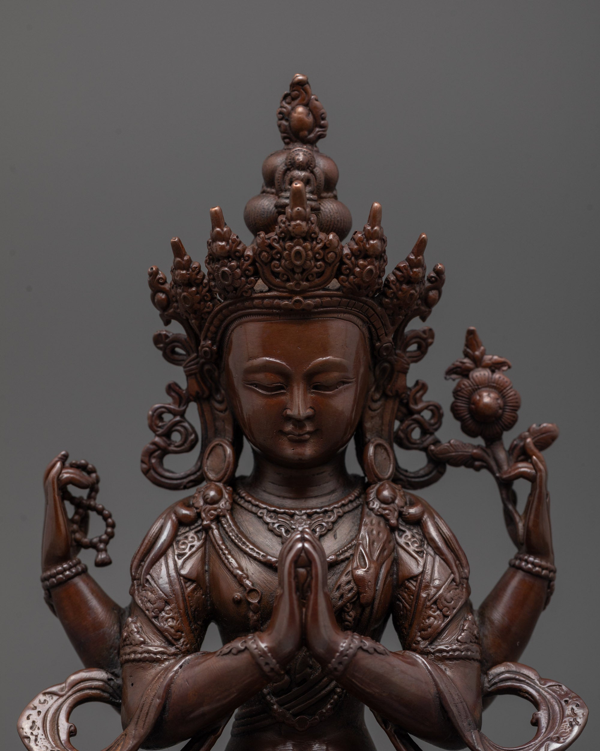 Close-up of Chenrezig statue highlighting intricate machine-crafted details and dark tone