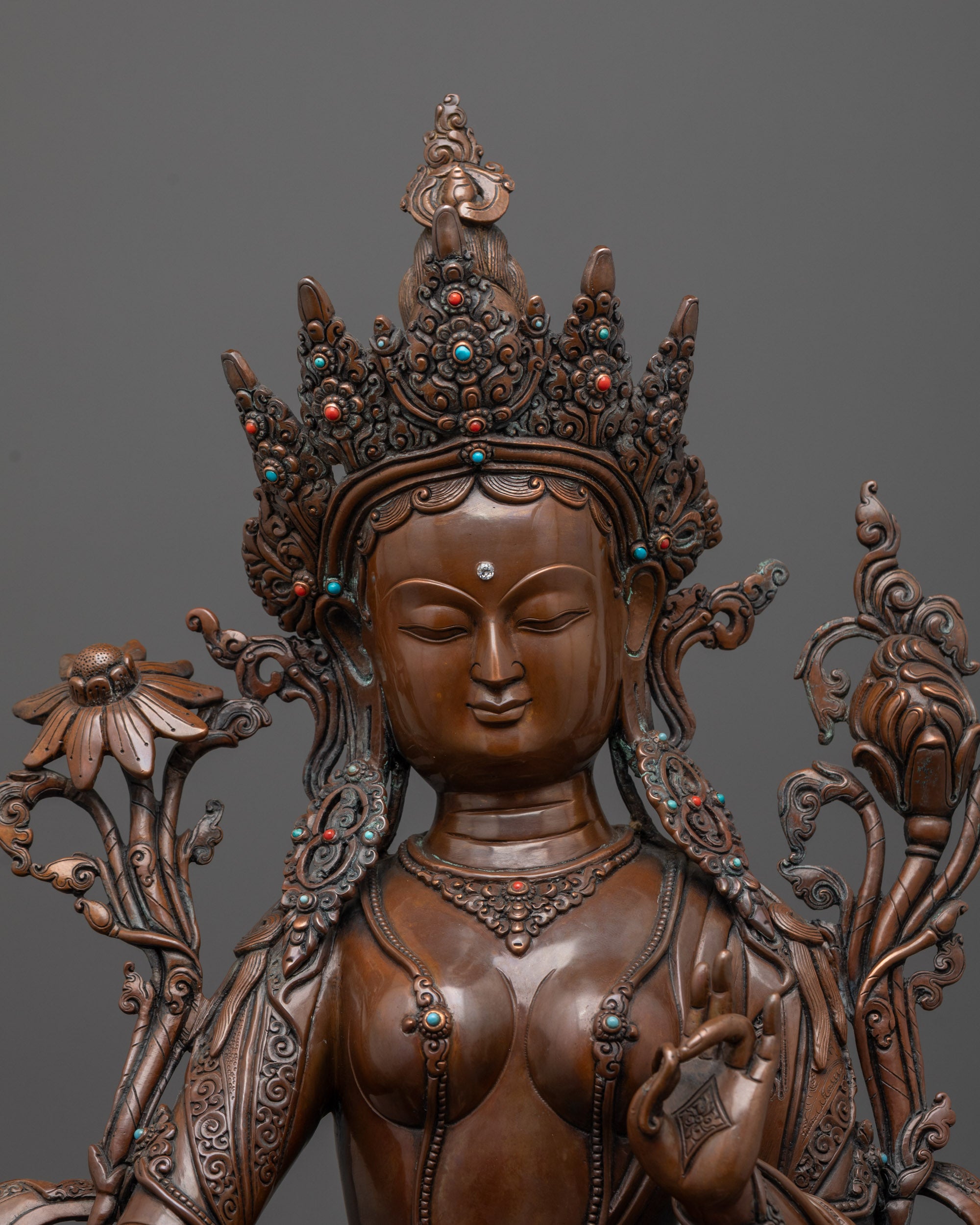 close-up of green tara statue face showing oxidized copper finish and fine details