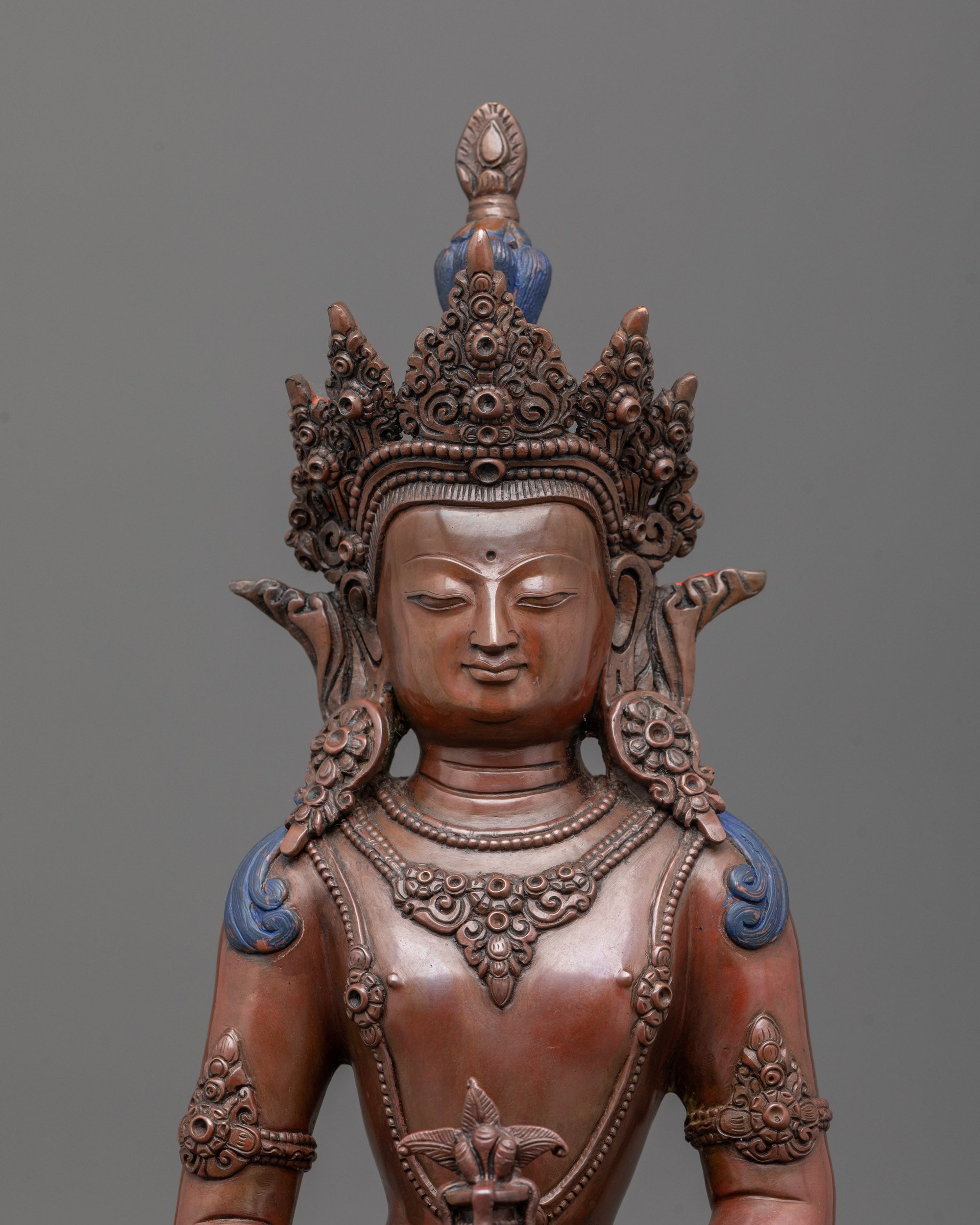 close-up of oxidized Amitayus statue face showing intricate carvings and fine detailing
