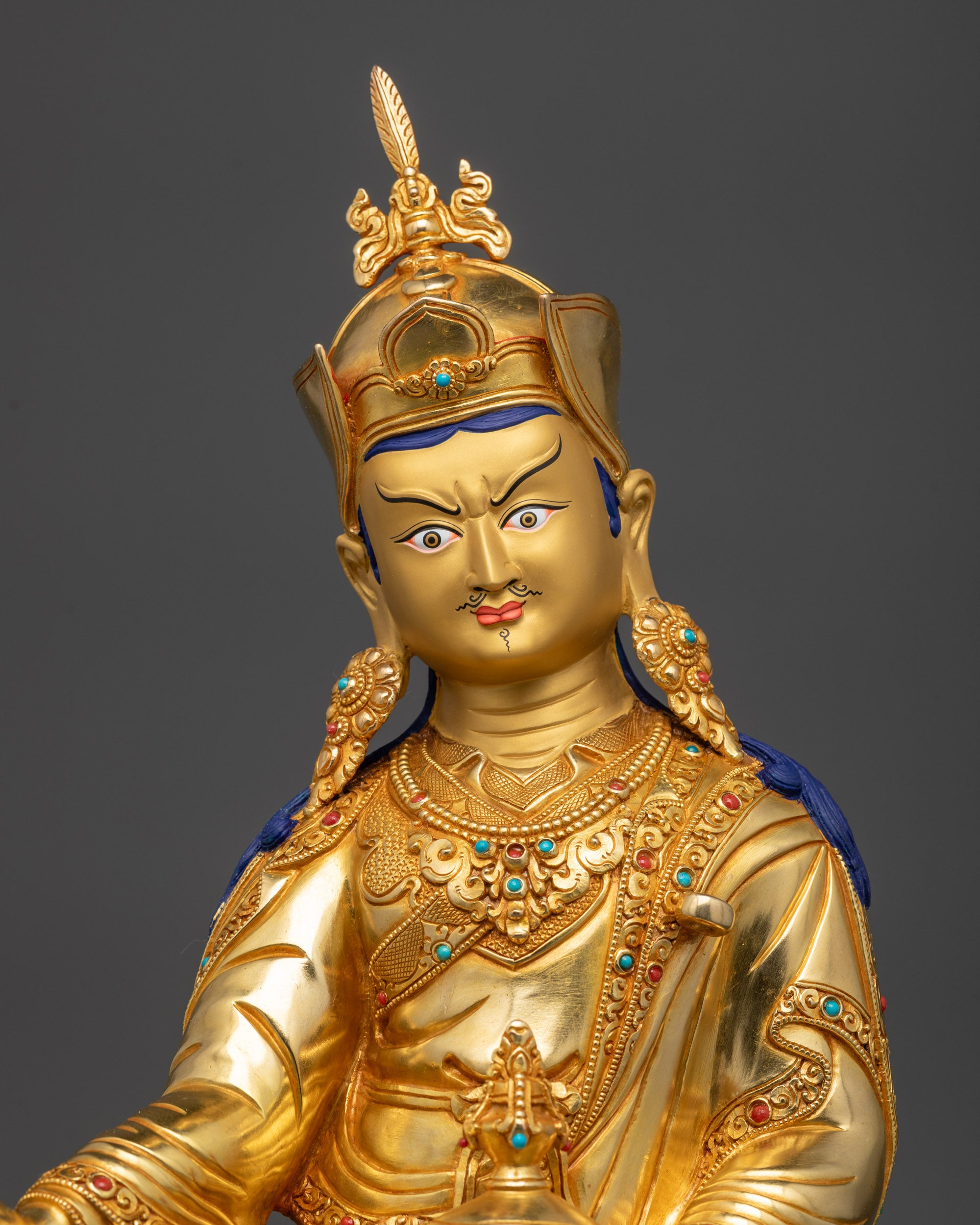 close up Guru Padmasambhava statue with semi-precious stones and carved patterns