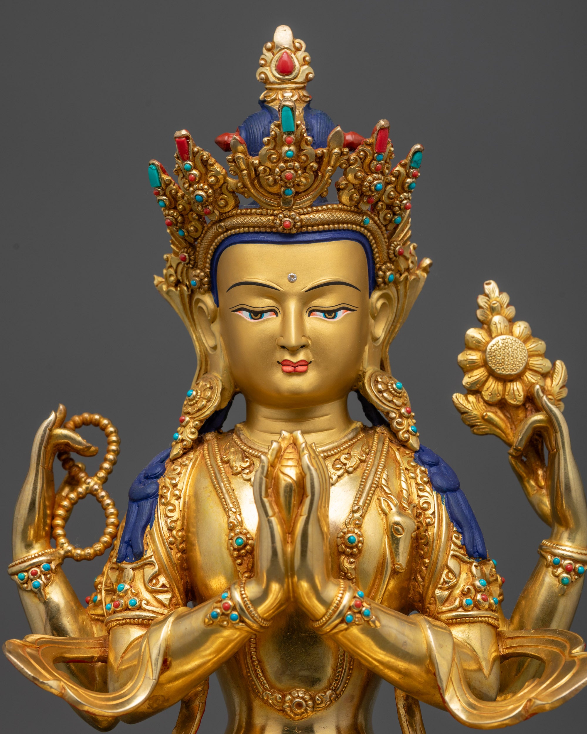 close up Nepalese Chenrezig statue showing flowing robe and intricate carvings