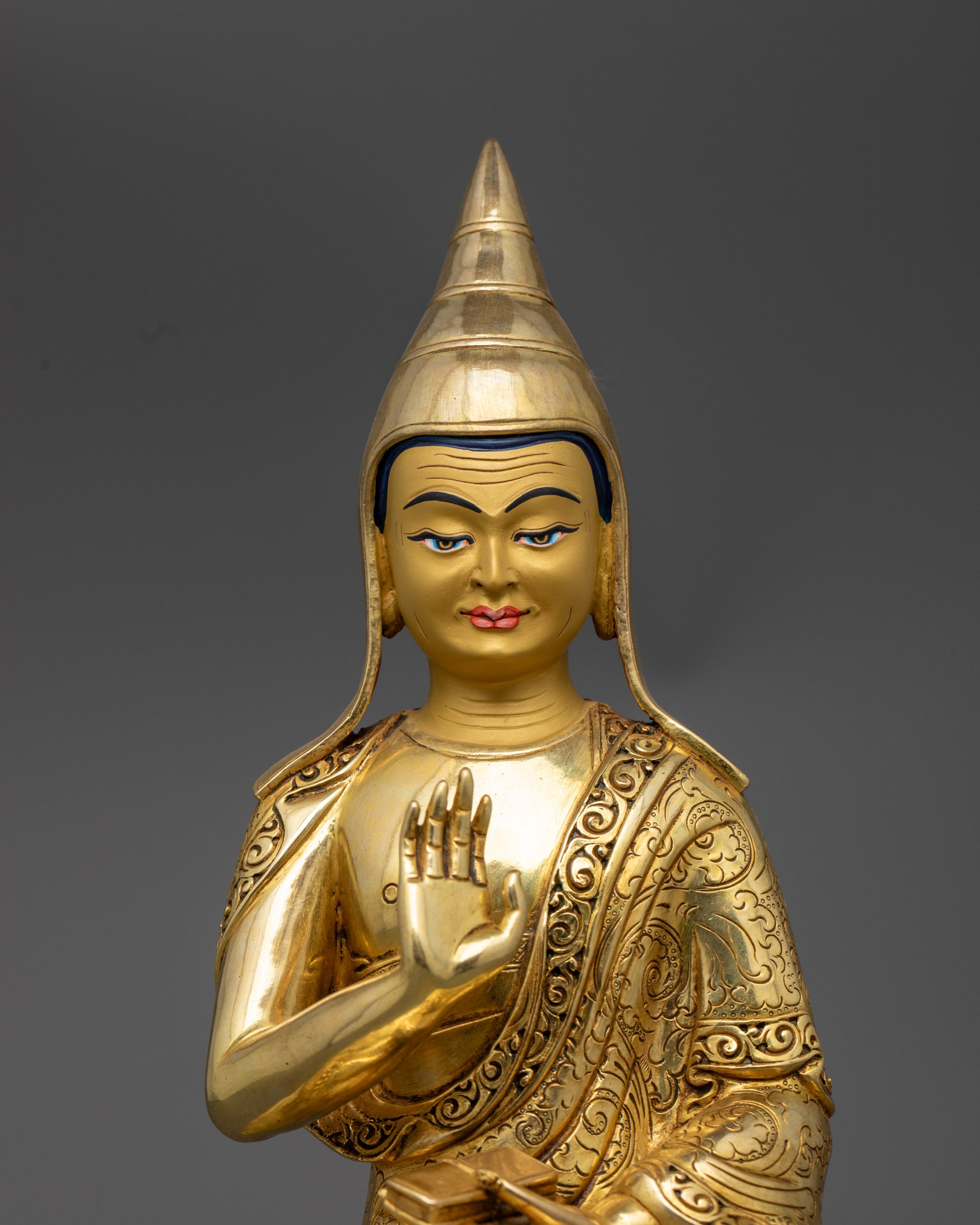 close up Santaraksita statue holding Vajrayana scriptures and performing abhaya mudra