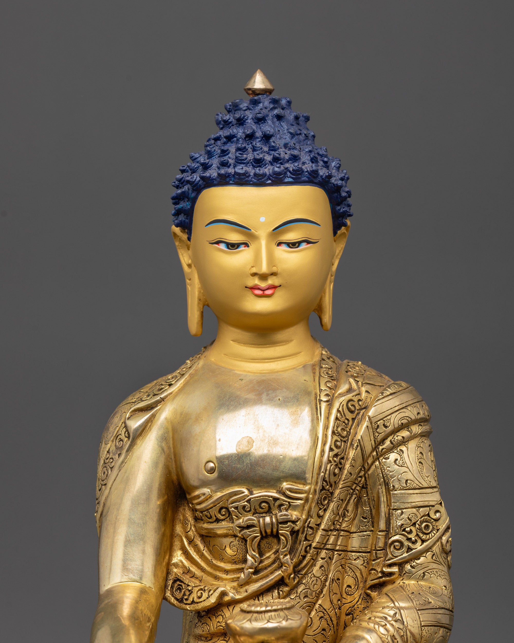 close up Shakyamuni Buddha gold-gilded face and patra bowl details