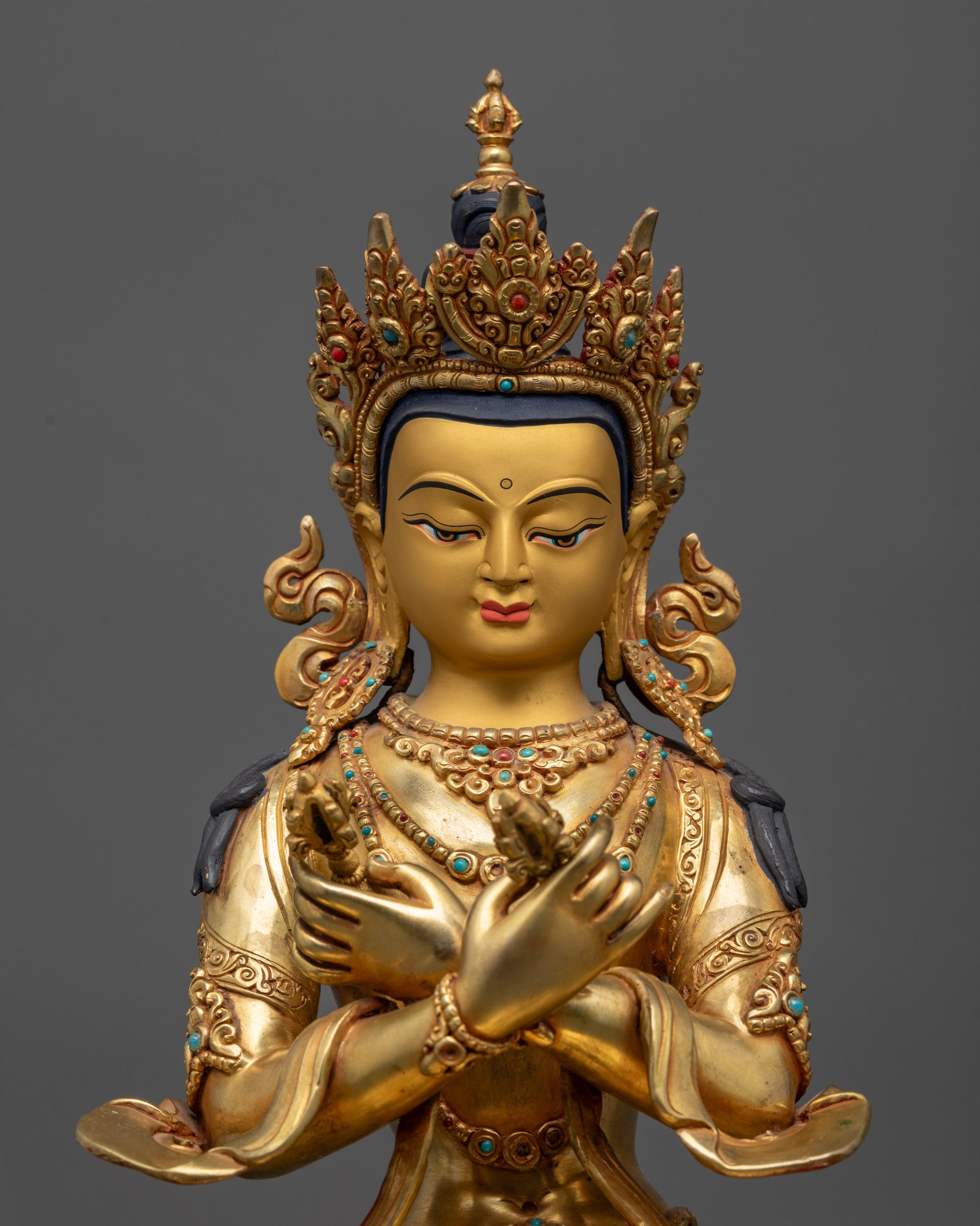 close up Vajradhara Buddha face with five-jeweled crown and semi-precious stone earrings