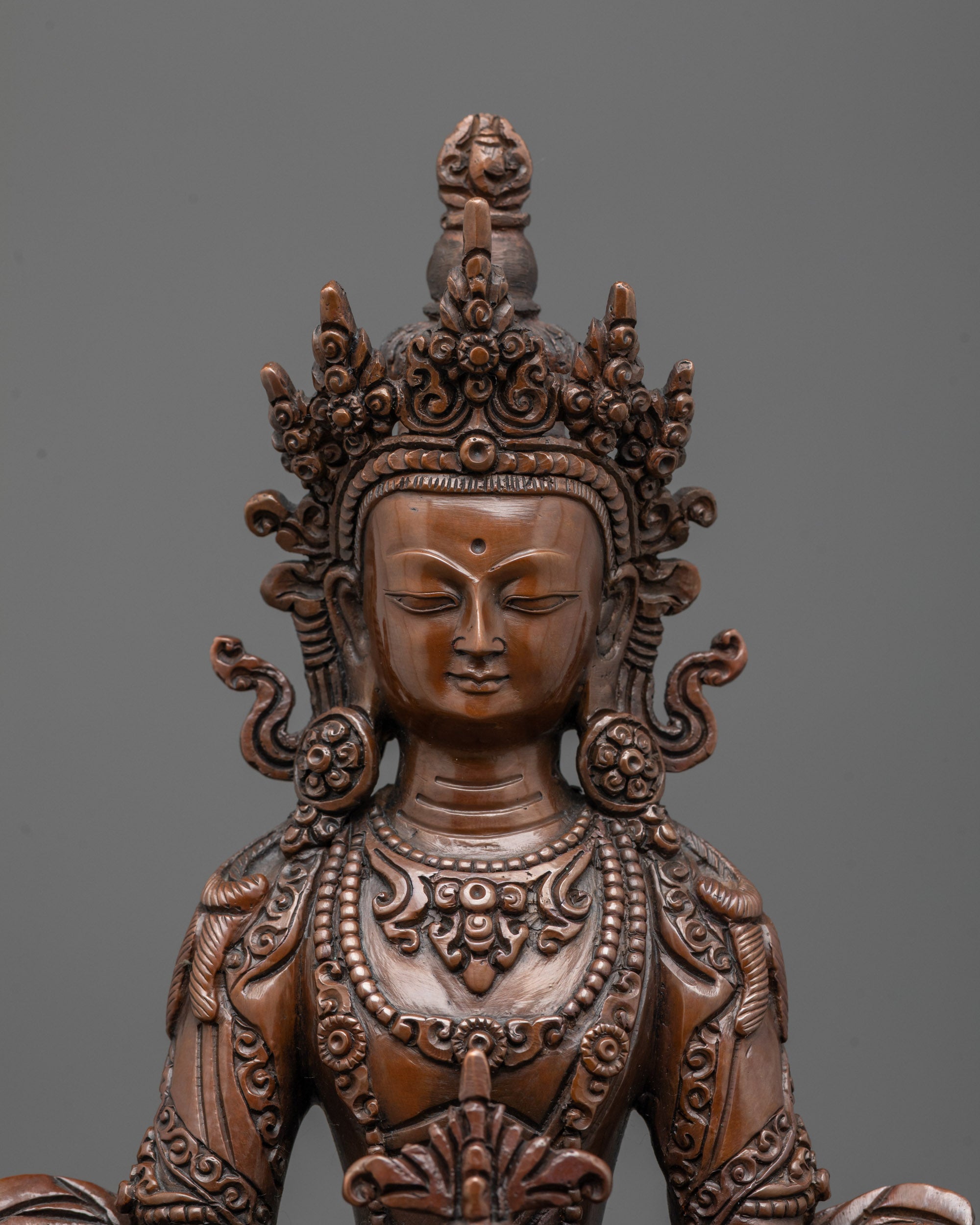 close up of Amitayus statue showing carved jewelry crown and patterned robe details