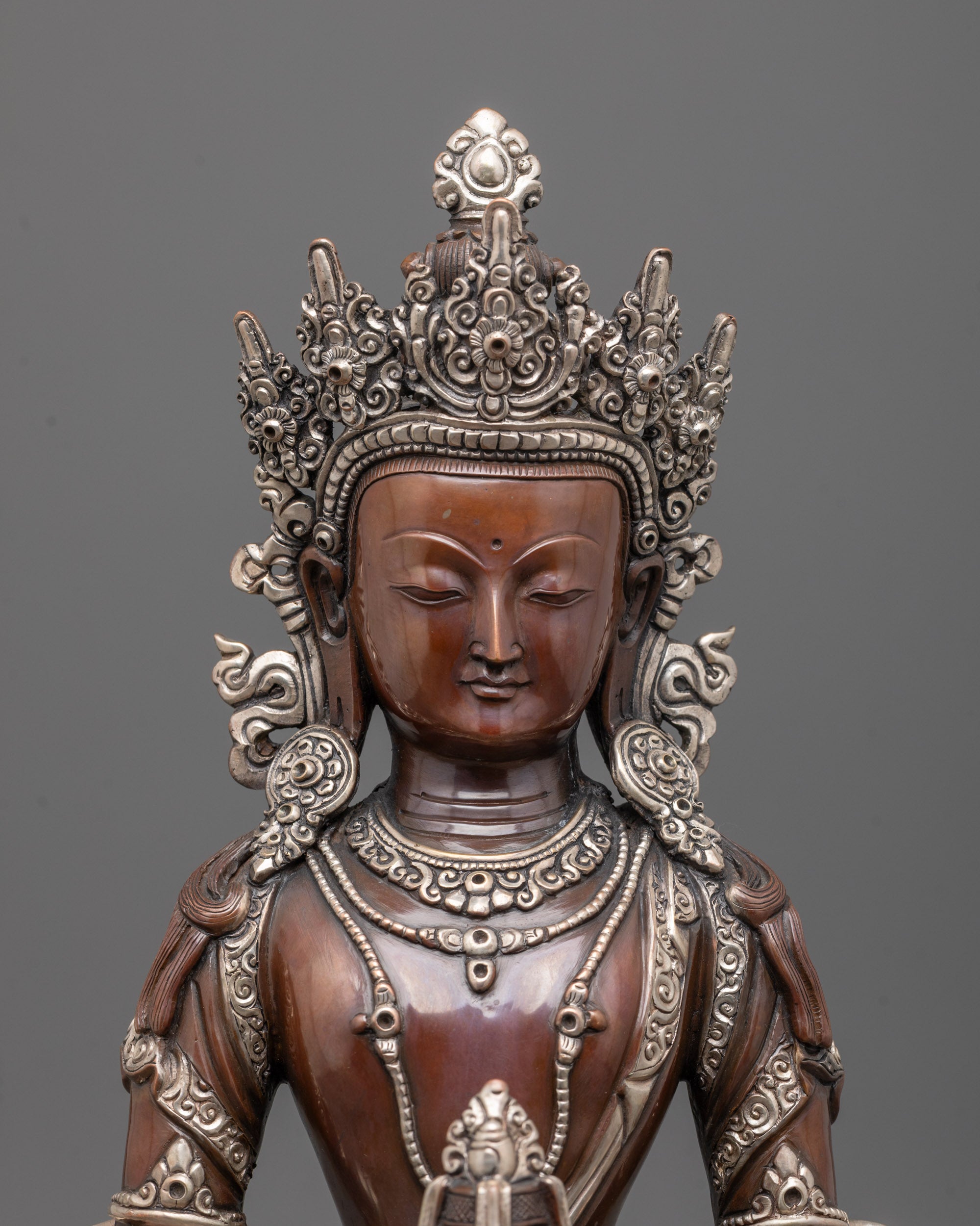 close up of amitayus statue showing nectar vase and hand-carved jewelry details