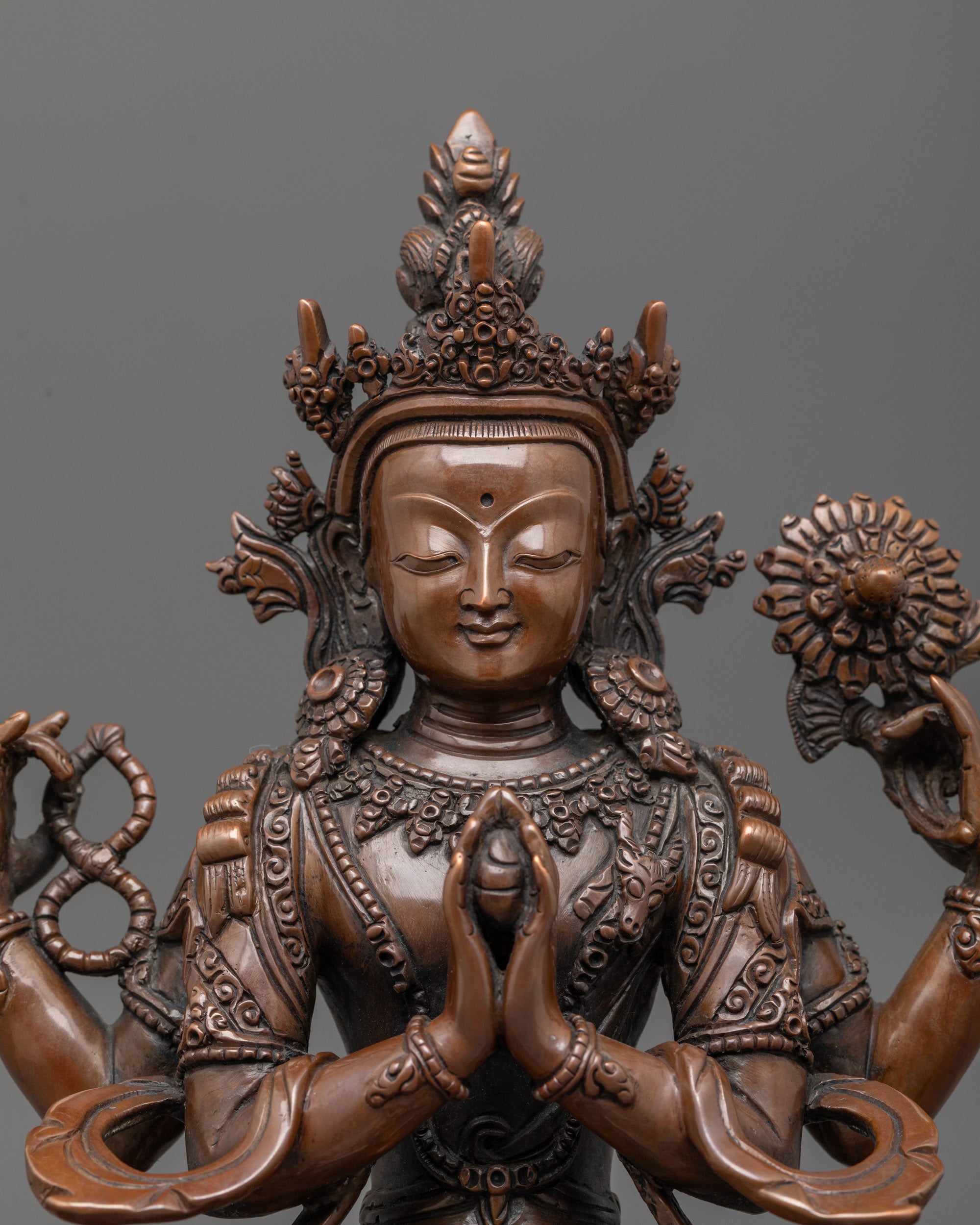 close up of chenrezig face showing oxidized copper detailing and serene expression