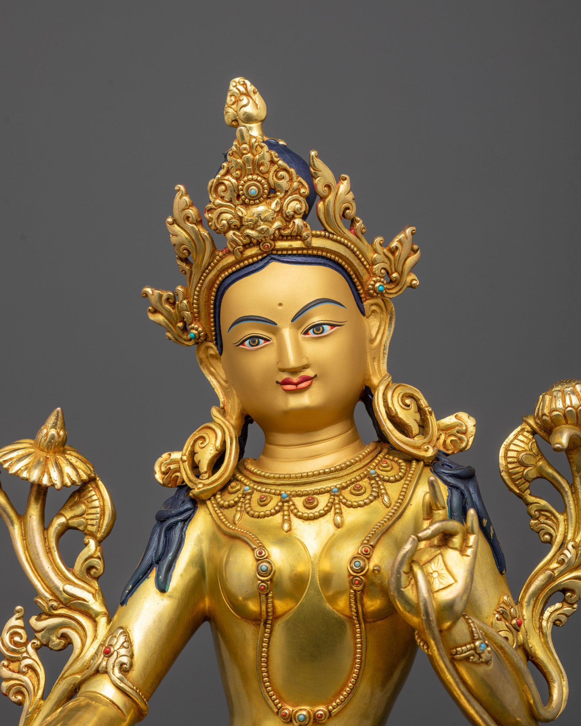 close up of green tara statue face showing fine carvings and 24k gold gilding from nepal