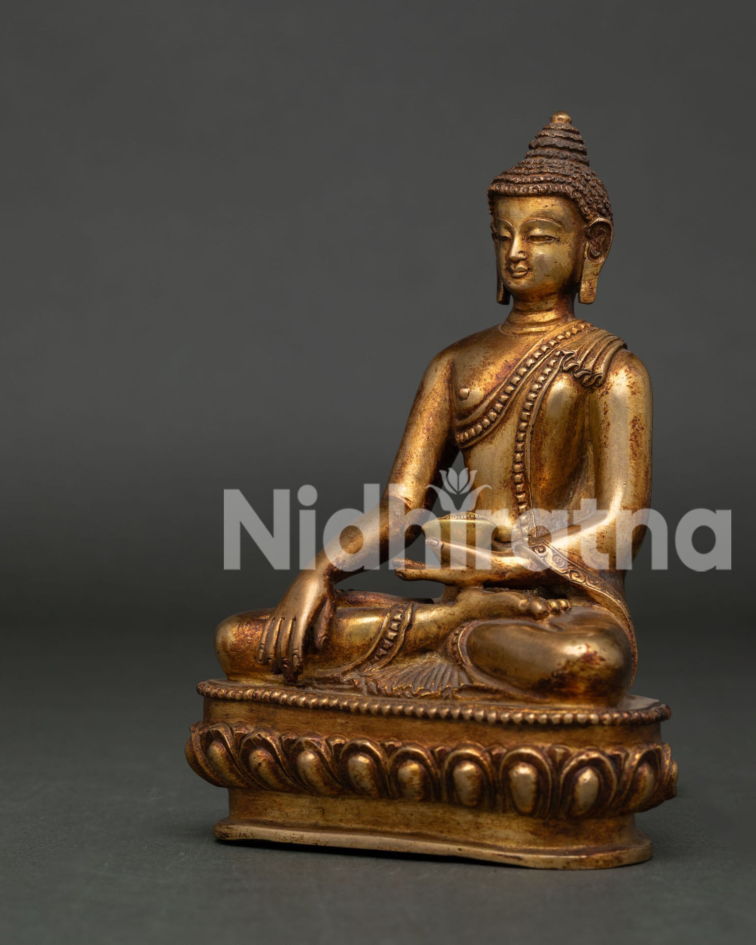 Copper Shakyamuni Buddha sculpture seated on lotus pedestal with earth touching mudra.
