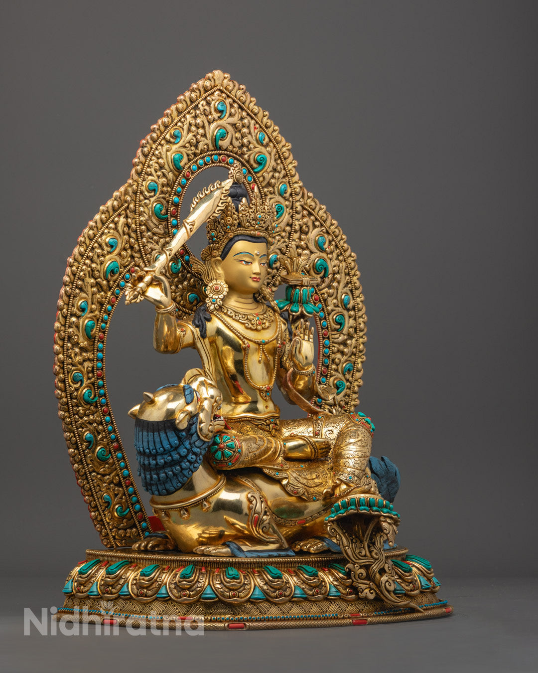 copper alloy base Manjushri statue with gold-fire gilding, showcasing ornate halo and semi-precious stone embellishments.
