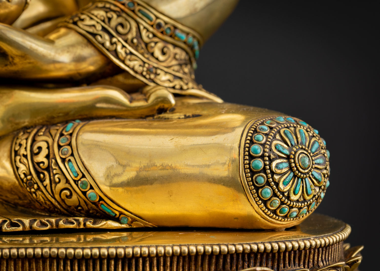 Detail of Shakyamuni Buddha statue ankle with turquoise inlay ornament and lotus pedestal petals