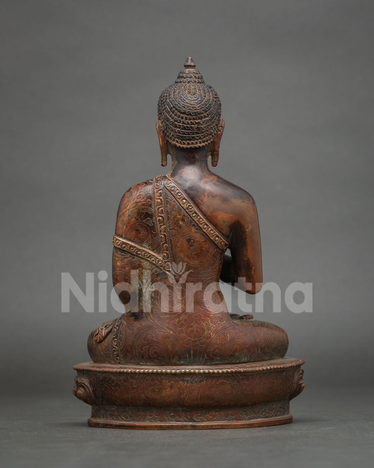 Detailed back view of antique finish copper Amoghasiddhi Buddha statue showing hand-carved motifs.