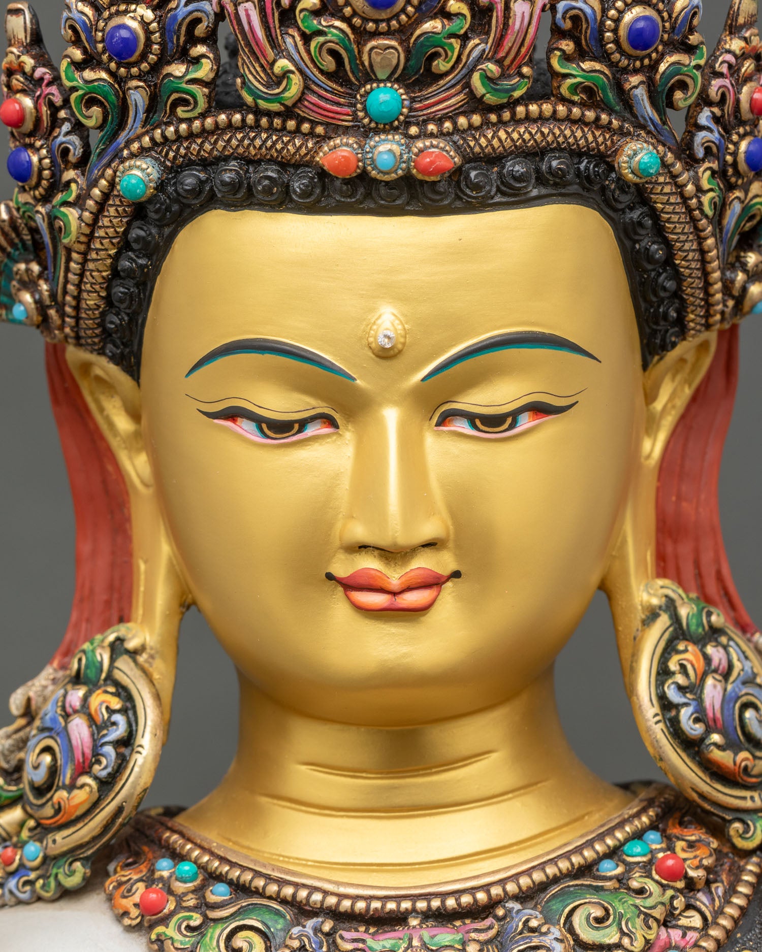 detailed close up face of crown shakyamuni buddha statue with serene expression and half-closed eyes