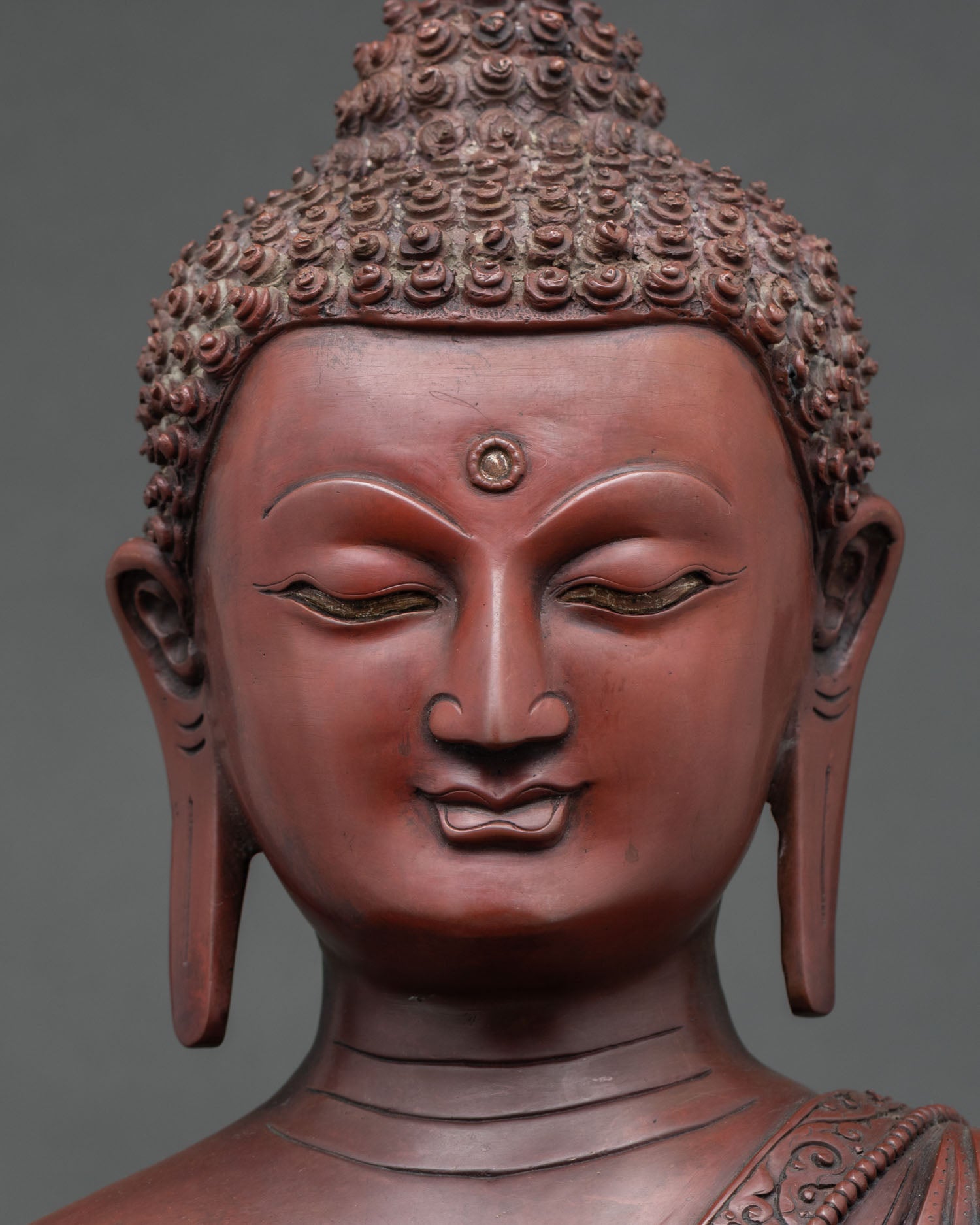Detailed close up face of Shakyamuni Buddha statue calm eyes and serene expression