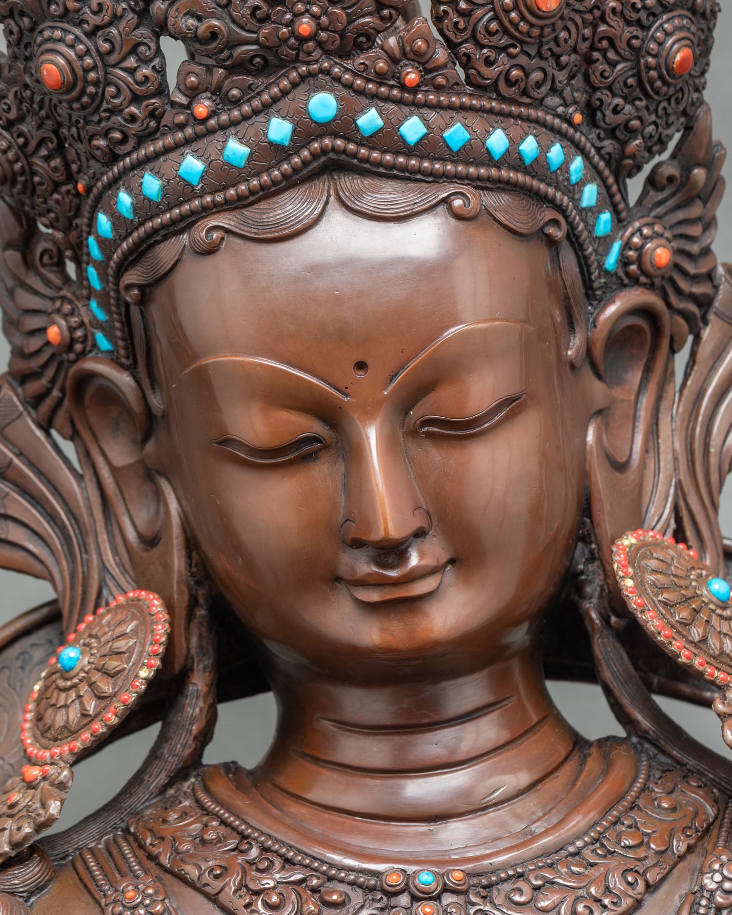 Detailed close-up of Green Tara statue highlighting intricate copper jewelry and crown
