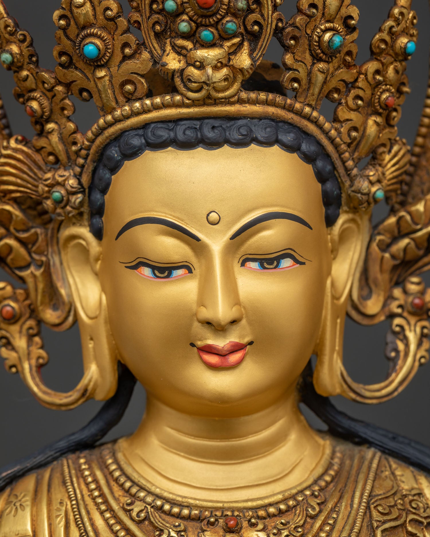 detailed close up of green tara face with serene expression and gold painted features