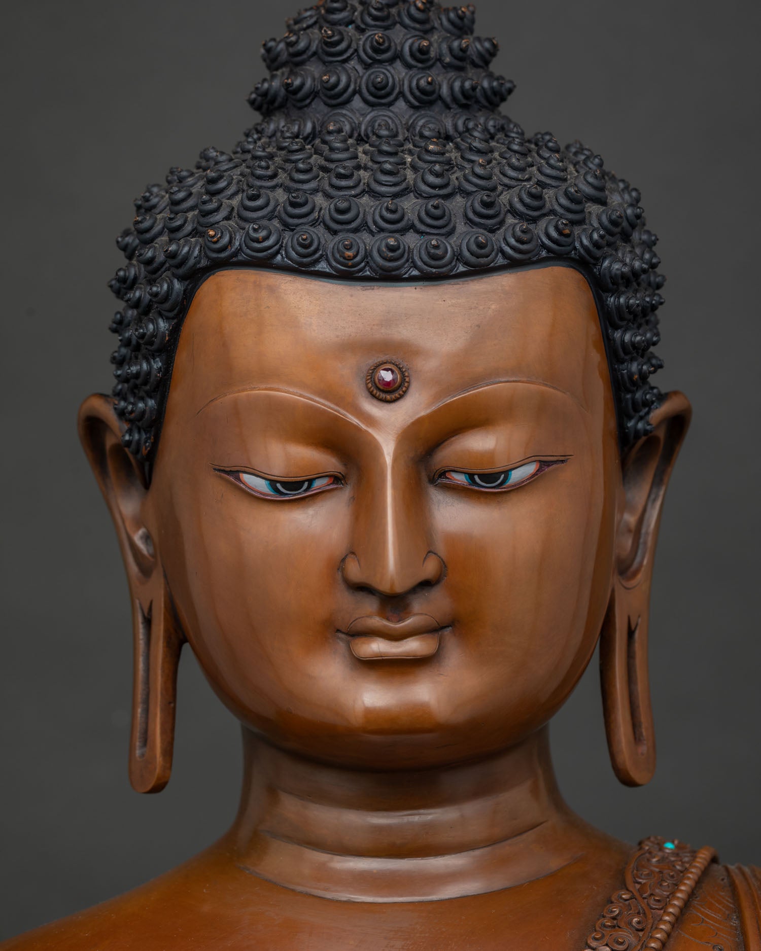 Detailed Close-Up of Serene Shakyamuni Buddha Face with Blue Painted Eyes