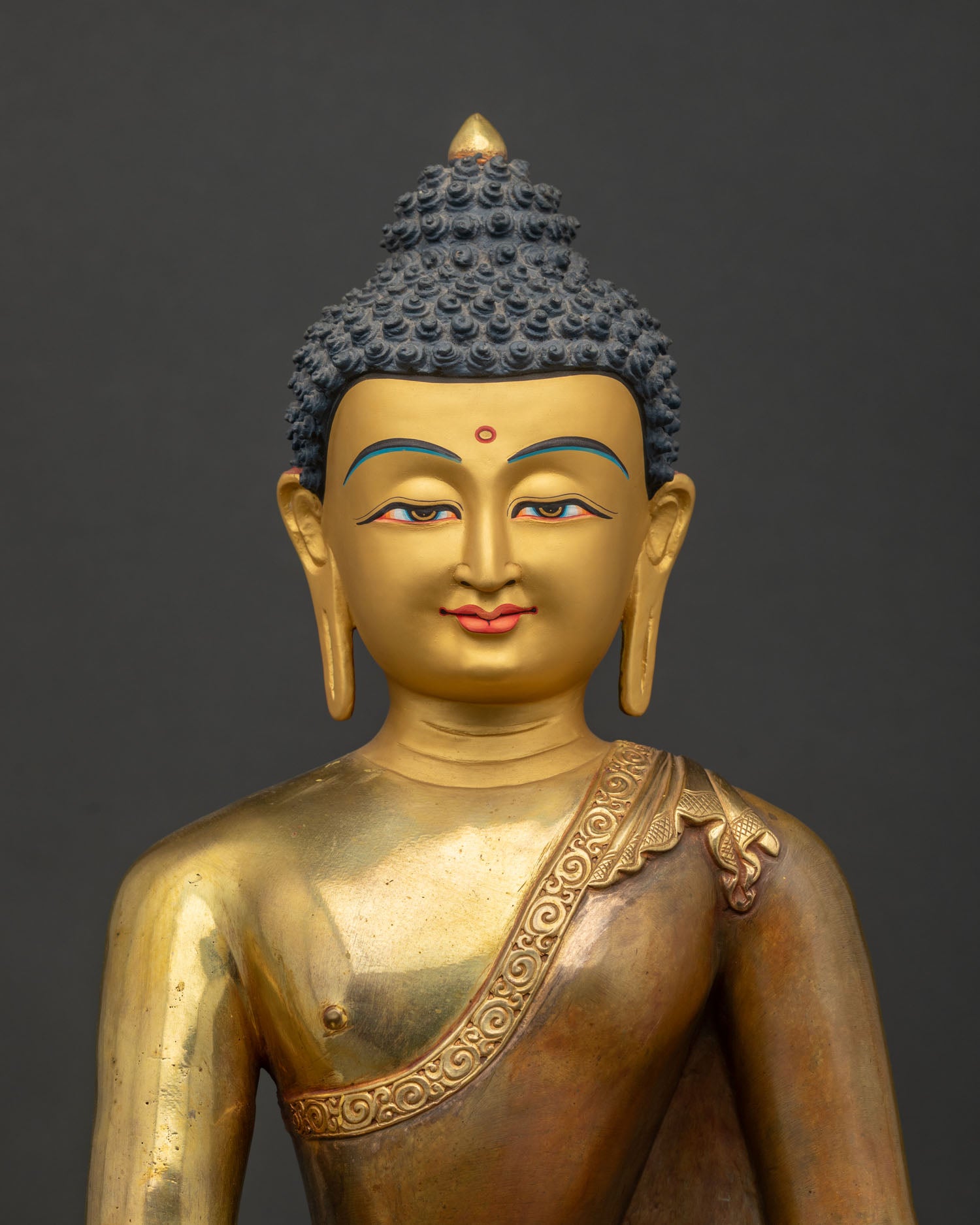 Detailed close-up of Shakyamuni Buddha sculpture with gold fire-gilding