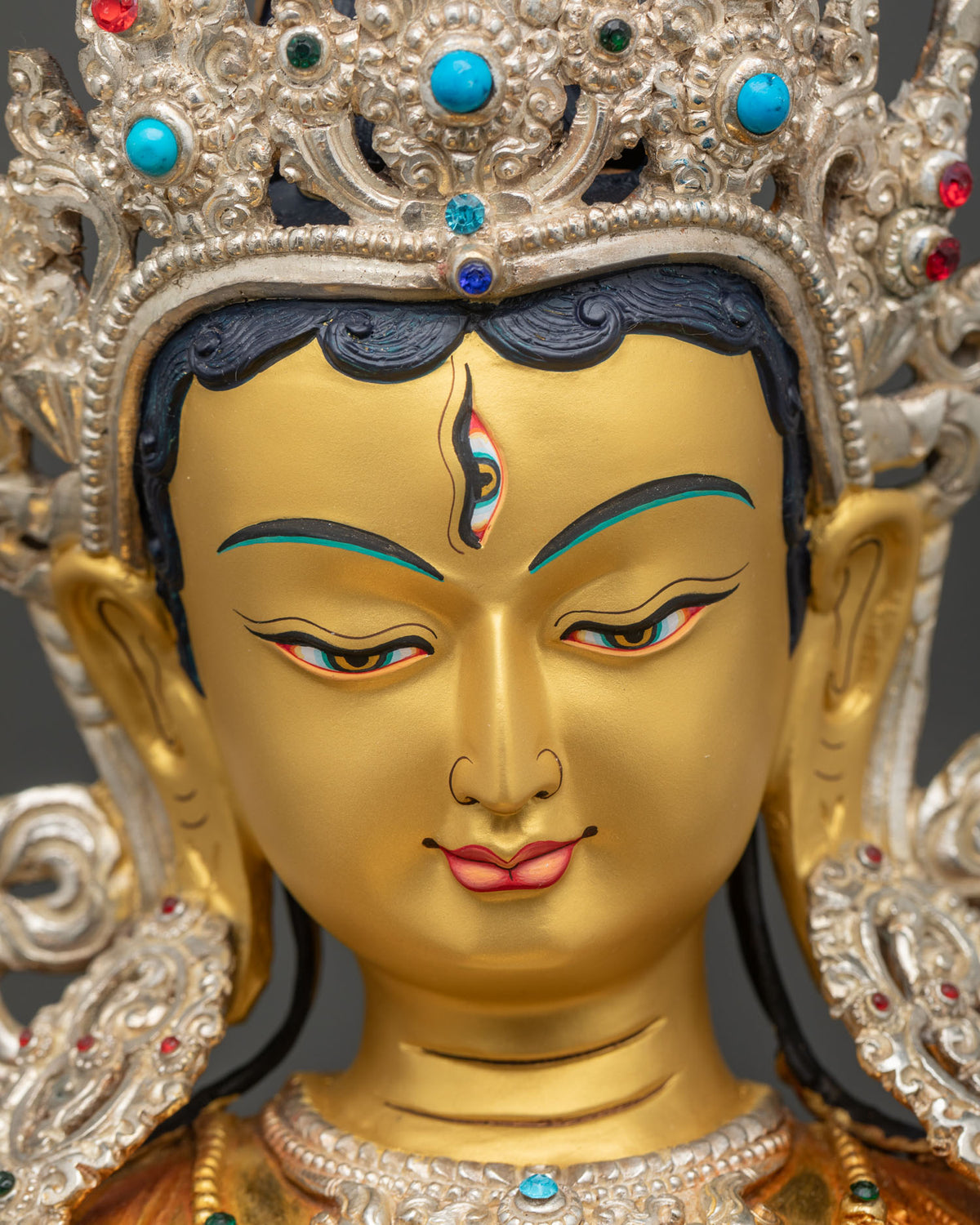 Detailed close up of Sitatapatra Dukar face with third eye and gemstone-inlaid silver crown, Nepal