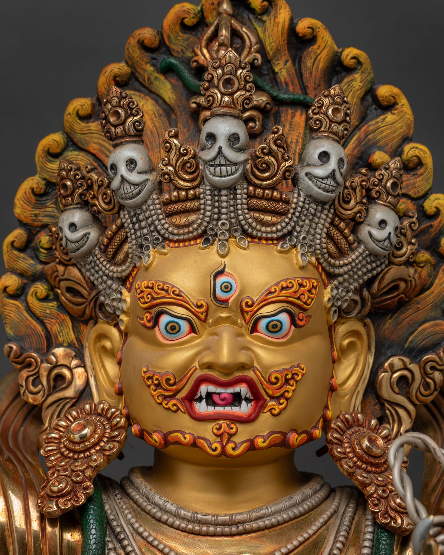 Detailed close-up of Vajrapani statue's wrathful face, gold-gilded copper Nepal art
