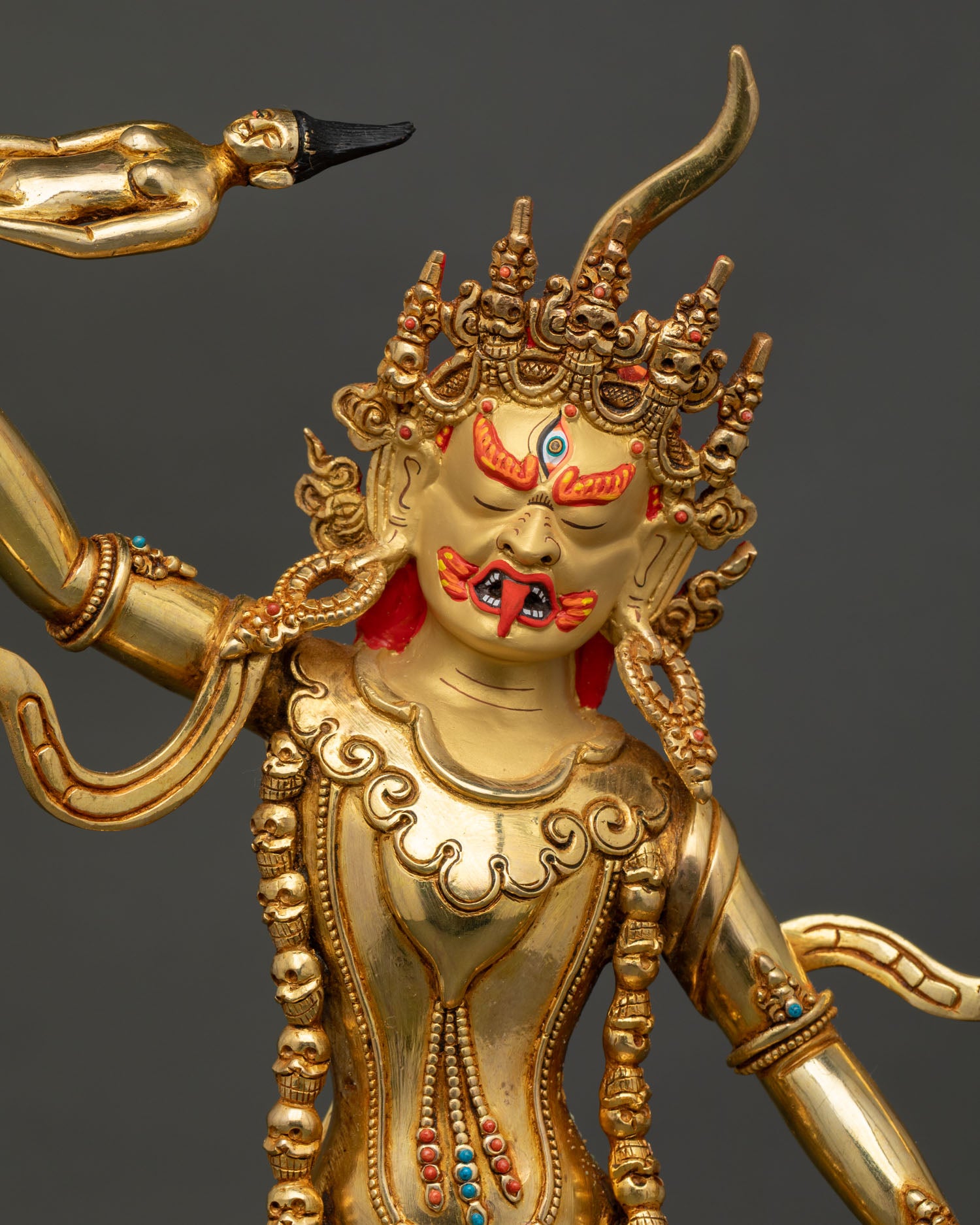 Detailed Face Close Up of Ekajati Statue with Gold Painted Expression and Skull Crown