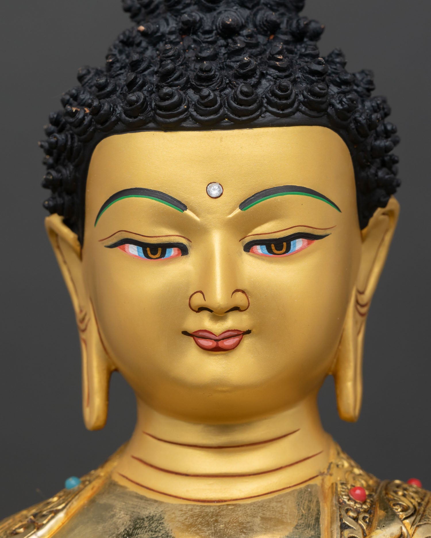 detailed face close up shakyamuni buddha serene expression gold painted face mineral pigments nepal artisan statue