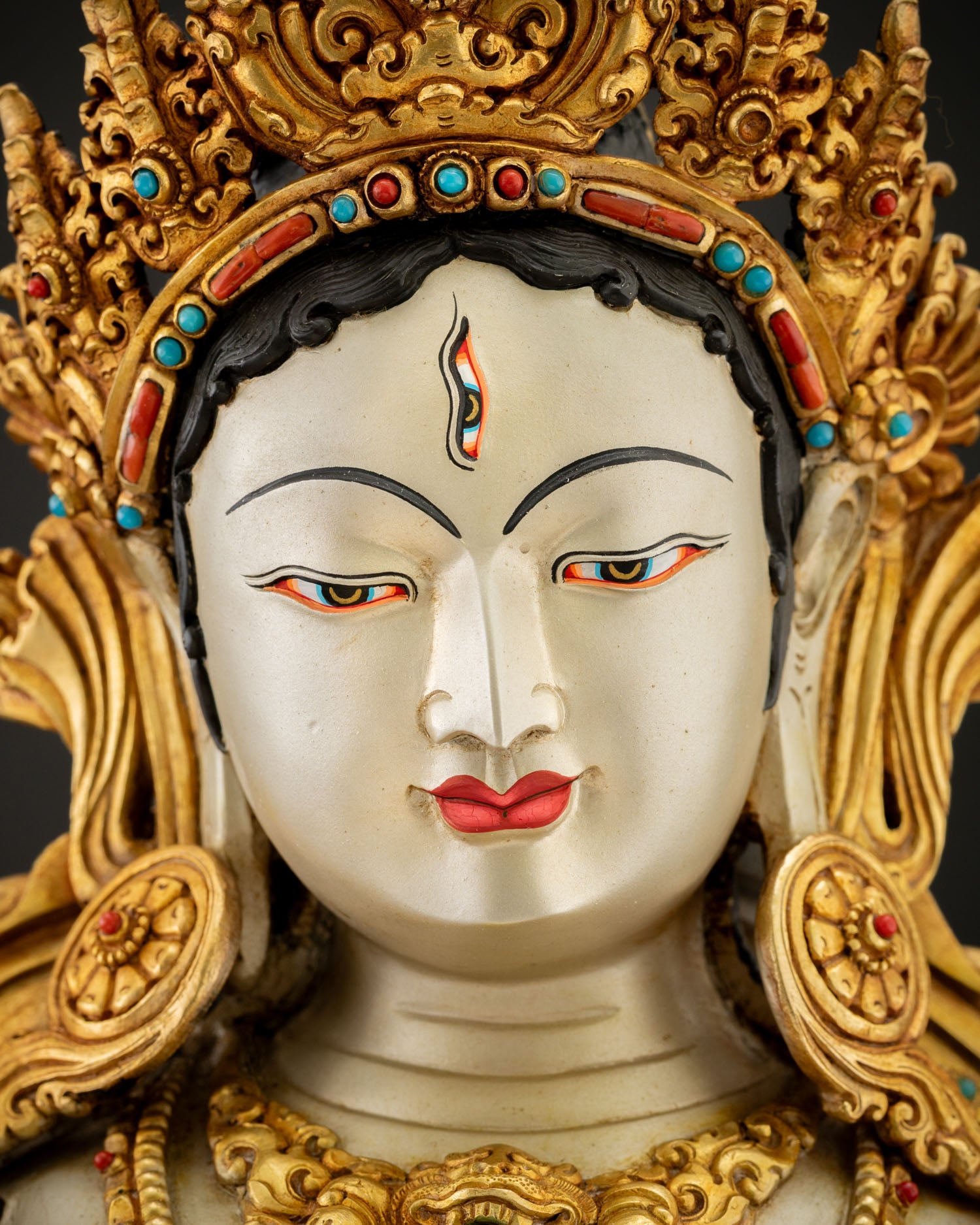 Detailed face of Dukar Sitatapatra statue — serene expression and seven all-seeing eyes