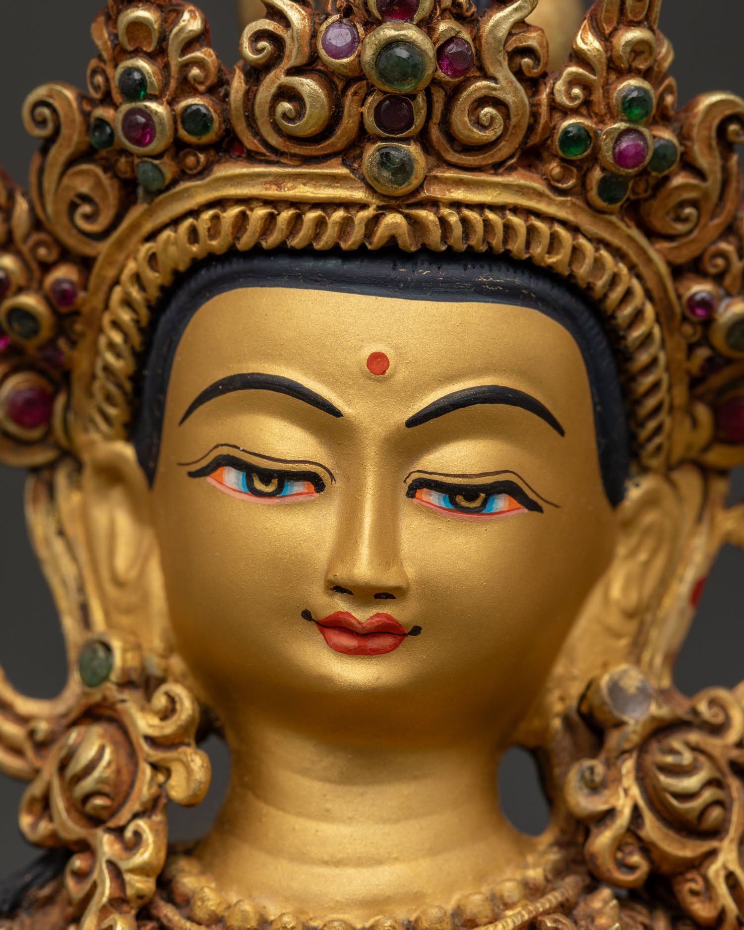 Detailed face of Manjushri statue with 24K gold painted features and wisdom expression
