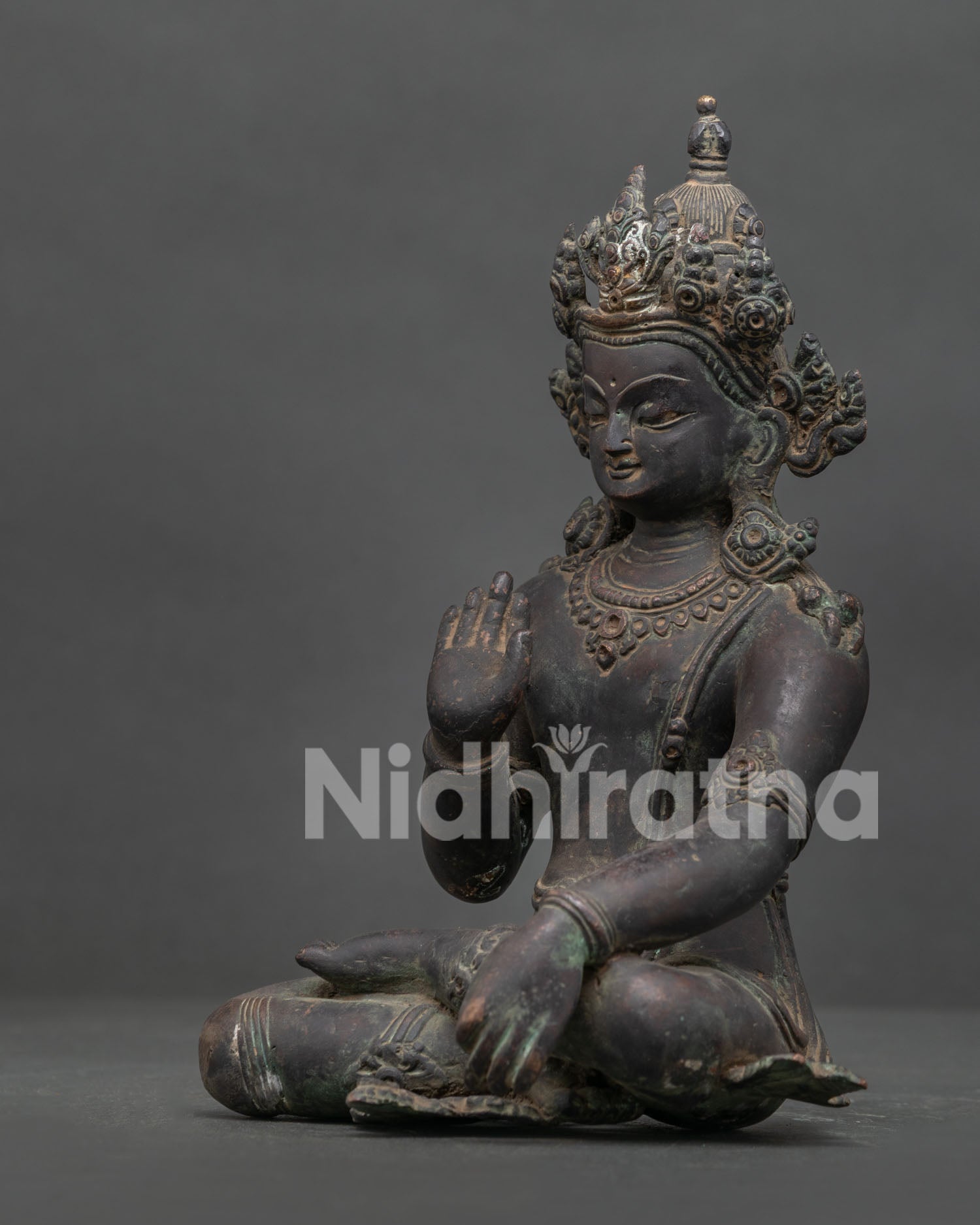 Detailed Lokeshvara statue side view with elaborate crown jewelry and sacred mudras.