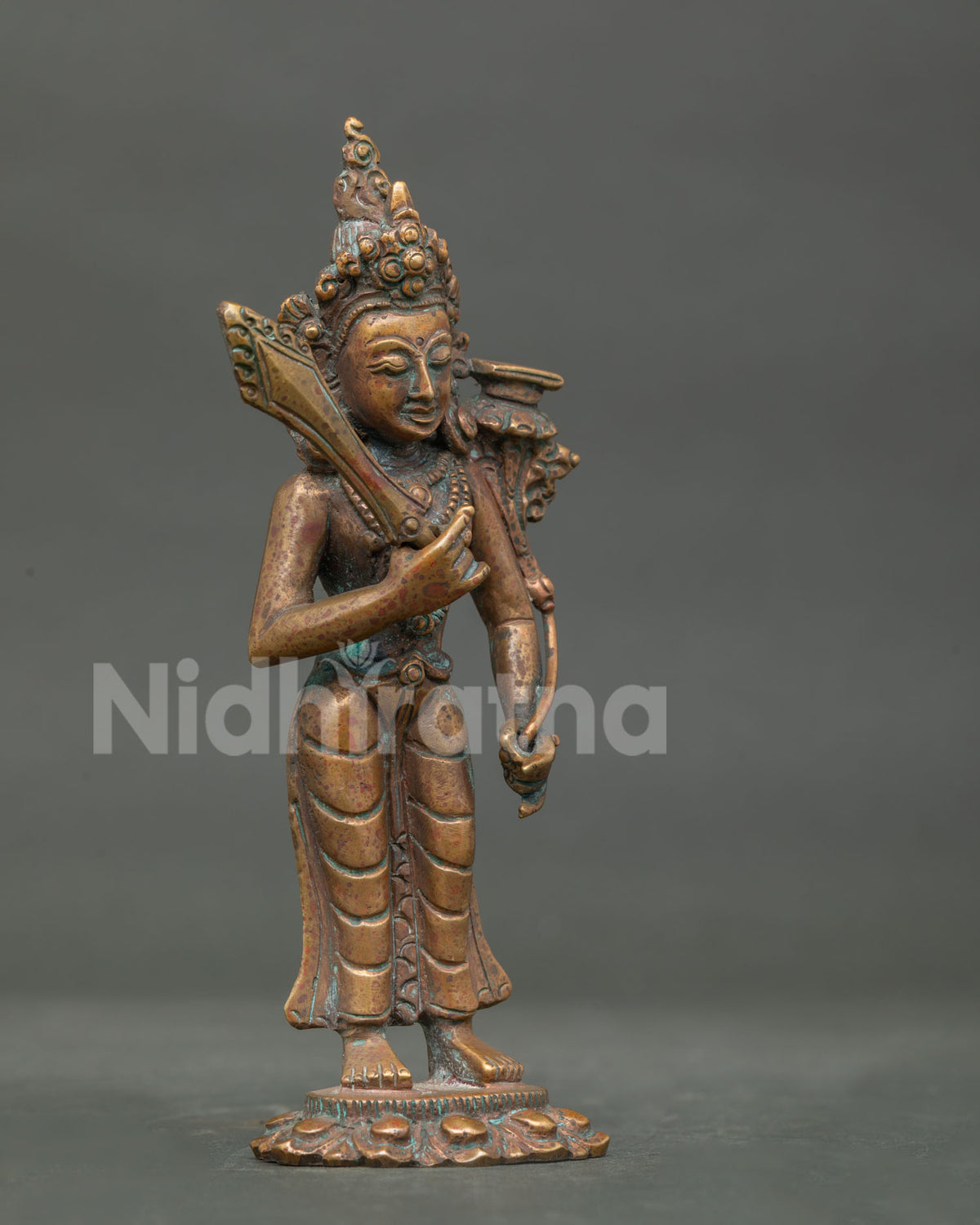 Detailed Manjushri statue face with refined copper craftsmanship and antique finish.