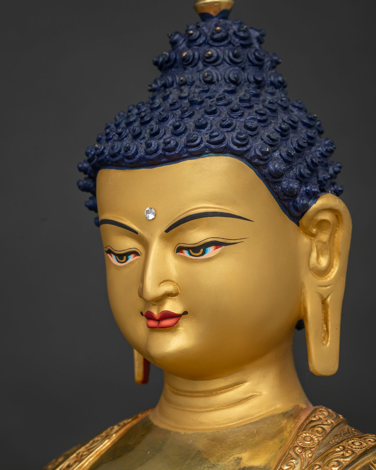 Side close-up of Shakyamuni Buddha face with 24K gold paint and serene expression