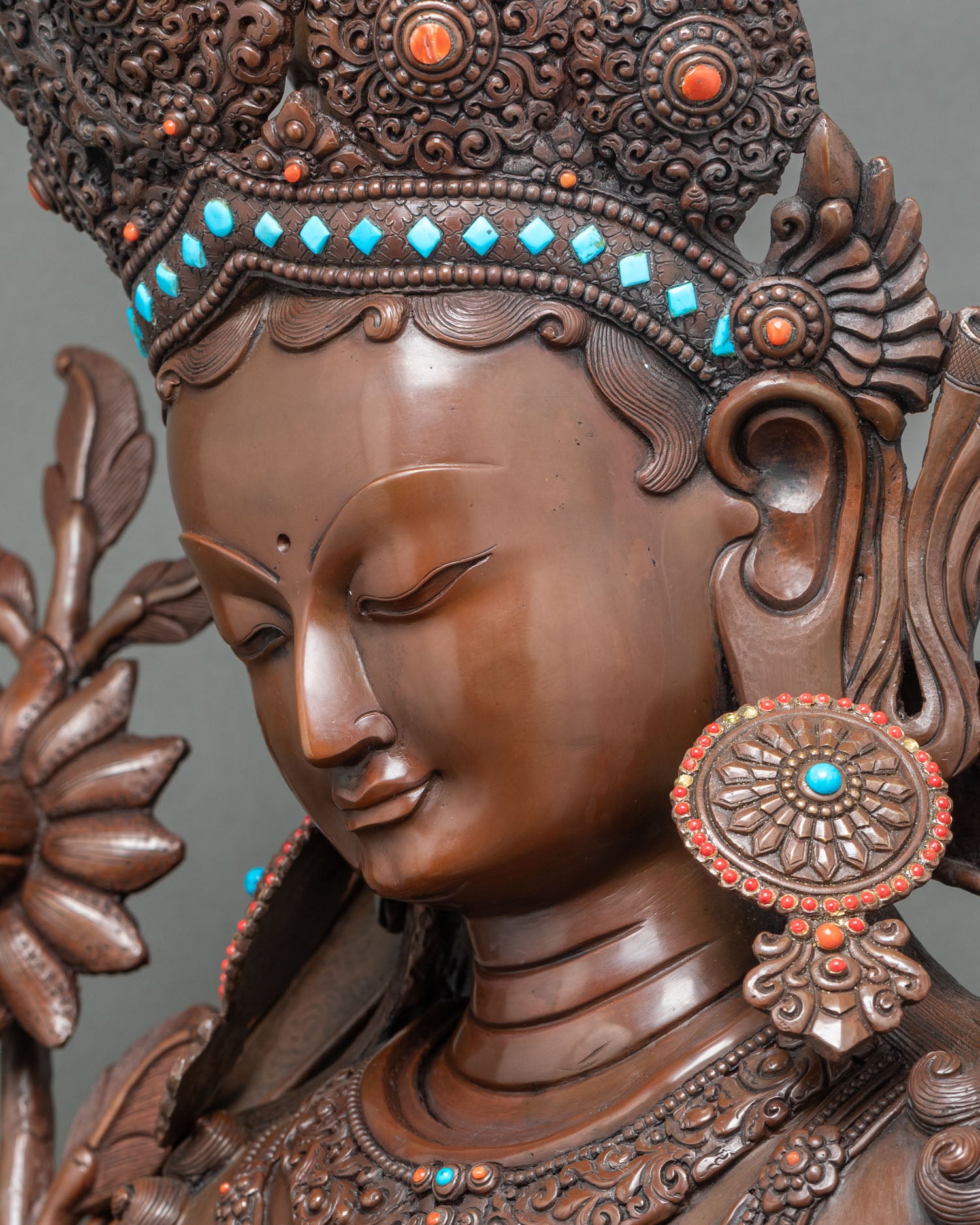 Detailed side close-up showing Green Tara statue’s swirling robe and armlet details
