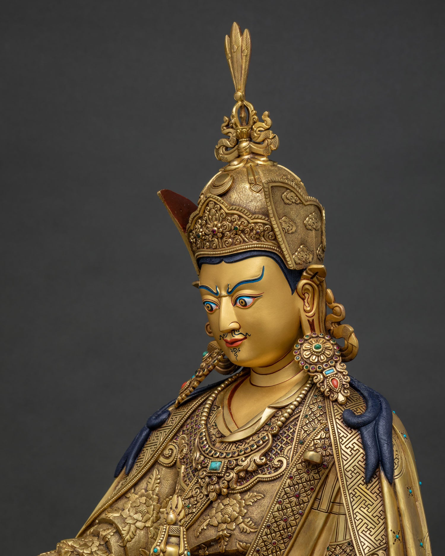 Detailed side close-up of khatvanga resting on Guru Rinpoche shoulder
